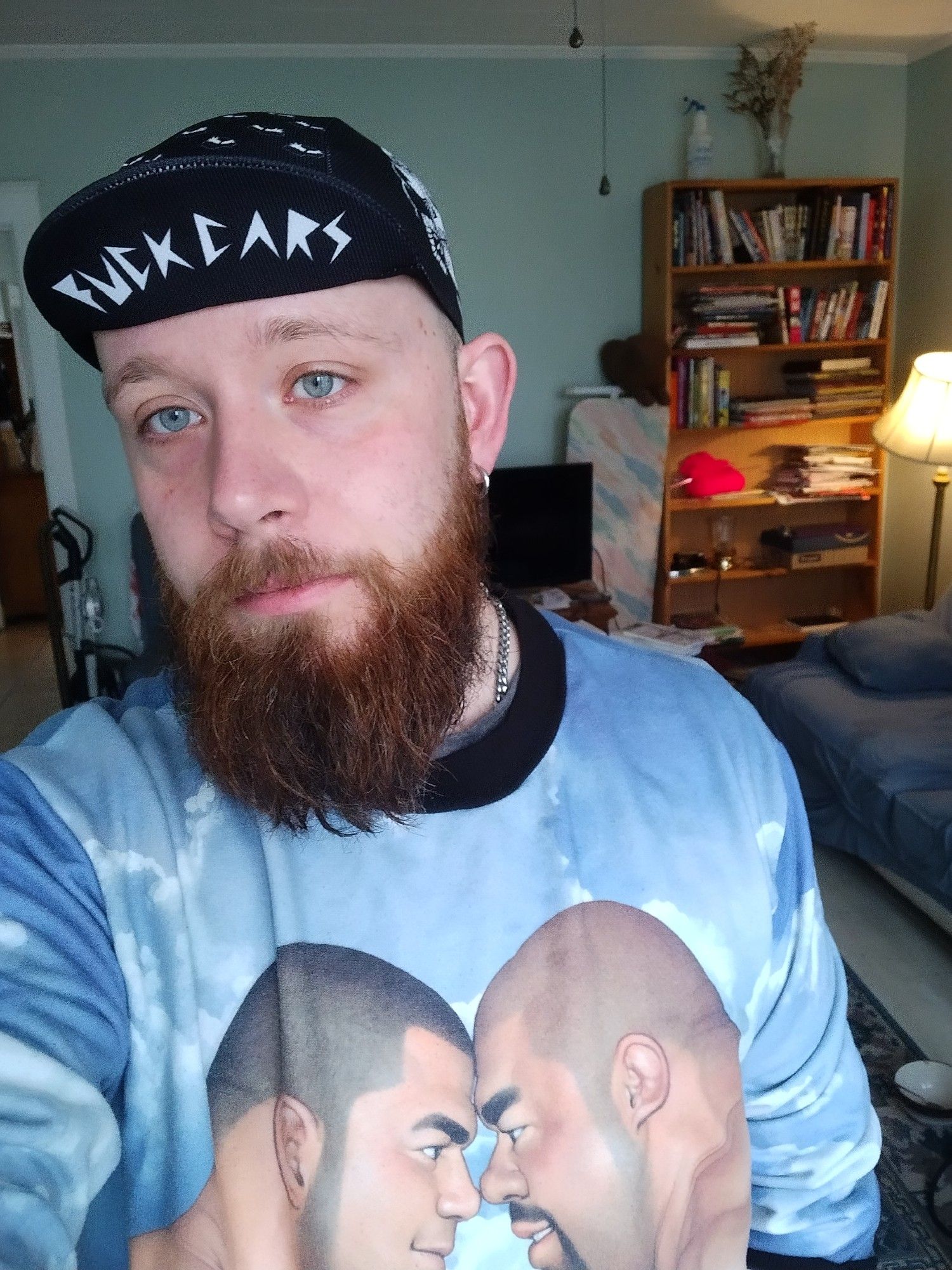 Me wearing a goofy little cycling cap that says "fuck cars" and a sweatshirt of 2 beefy dudes from MASSIVE, a defunct publisher/importer of gay manga