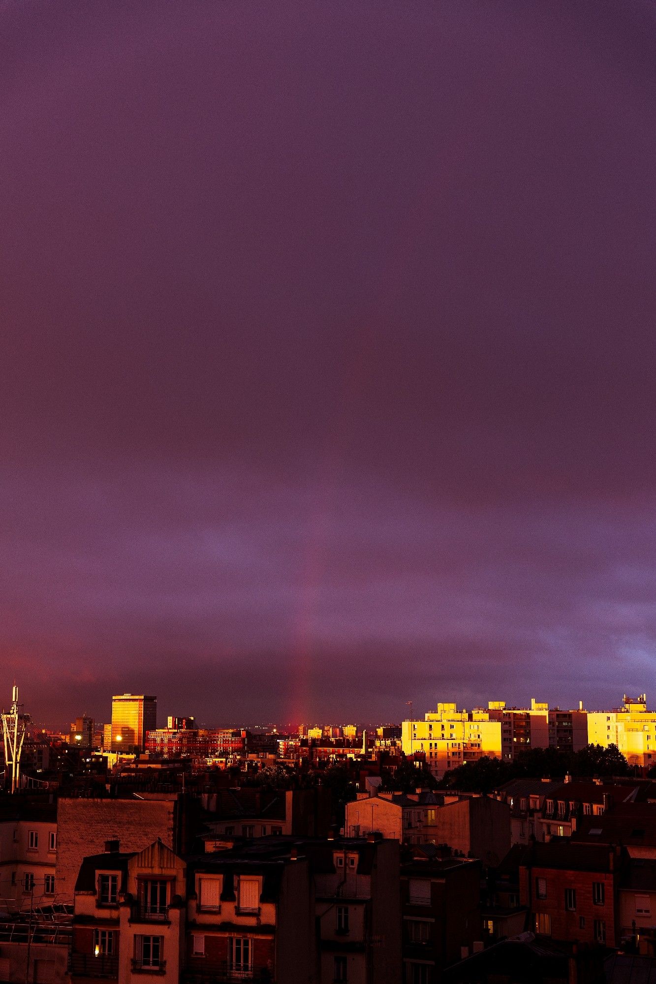 Un arc-en-ciel traverse le ciel au tout coucher du soleil