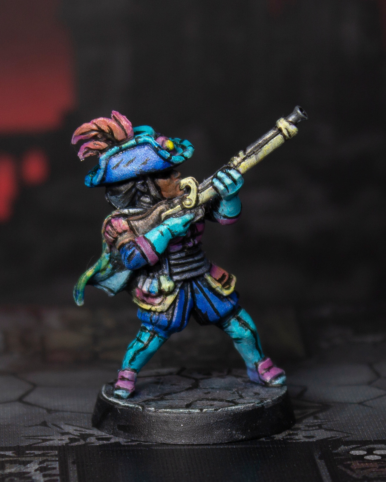 Photo of a painted miniature figure of a musketeer pointing their rifle upwards. The figure is painted with flat colors and bold black lines to mimic a cel-shaded illustration style.