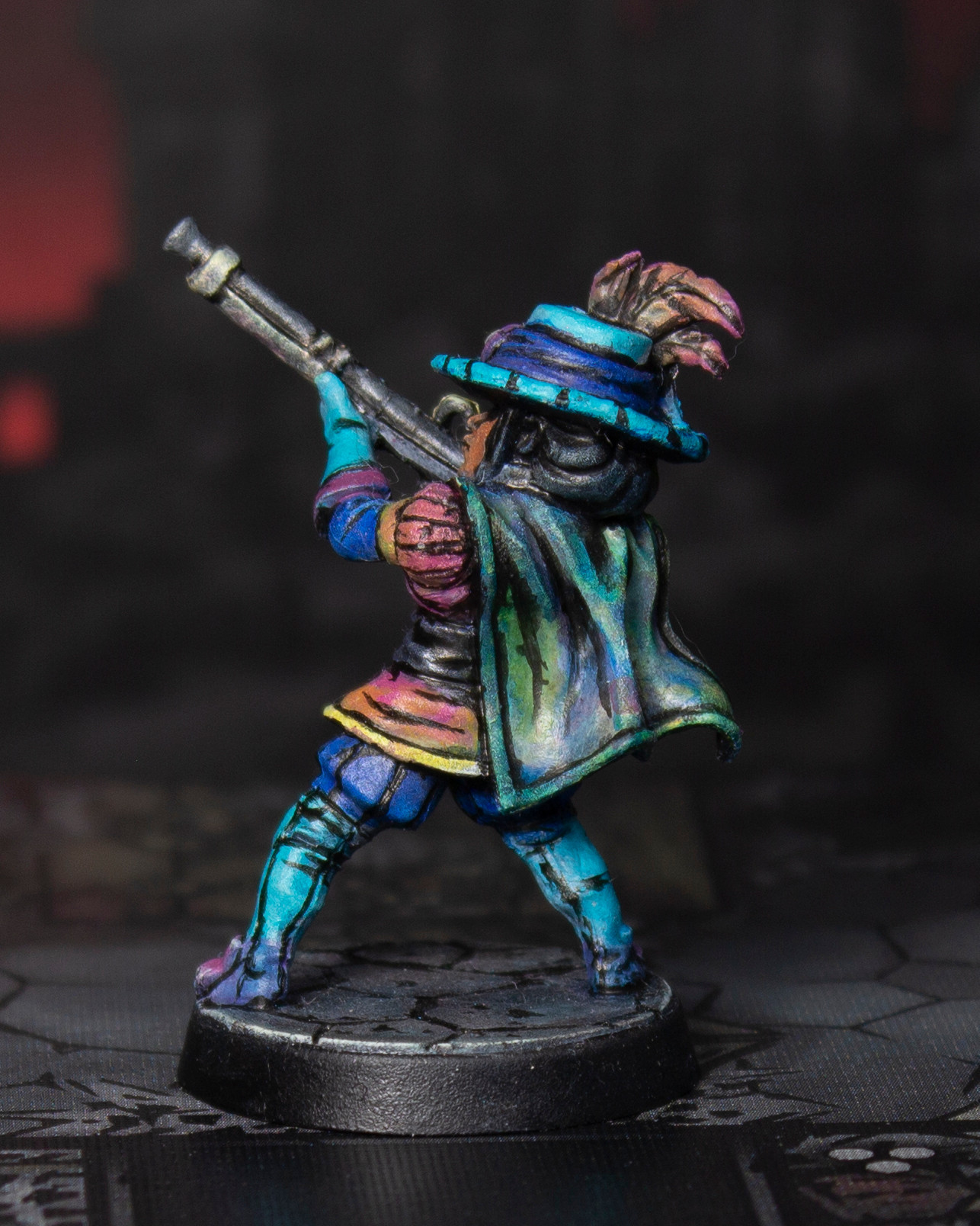 Photo of a painted miniature figure of a musketeer pointing their rifle upwards. The figure is painted with flat colors and bold black lines to mimic a cel-shaded illustration style.