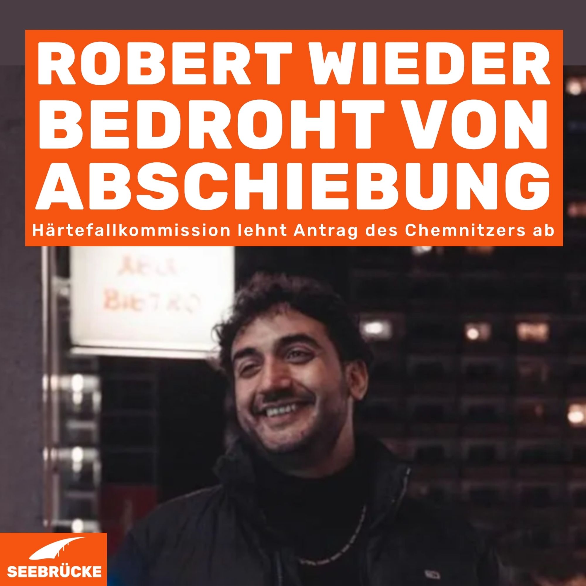 Foto von Robert. In einem orangen Kasten steht "Robert wieder bedroht von Abschiebung. Härtefallkommission lehnt Antrag des Chemnitzers ab". In der linken unteren Ecke ist das Seebrücke-Logo in weiß auf orange.