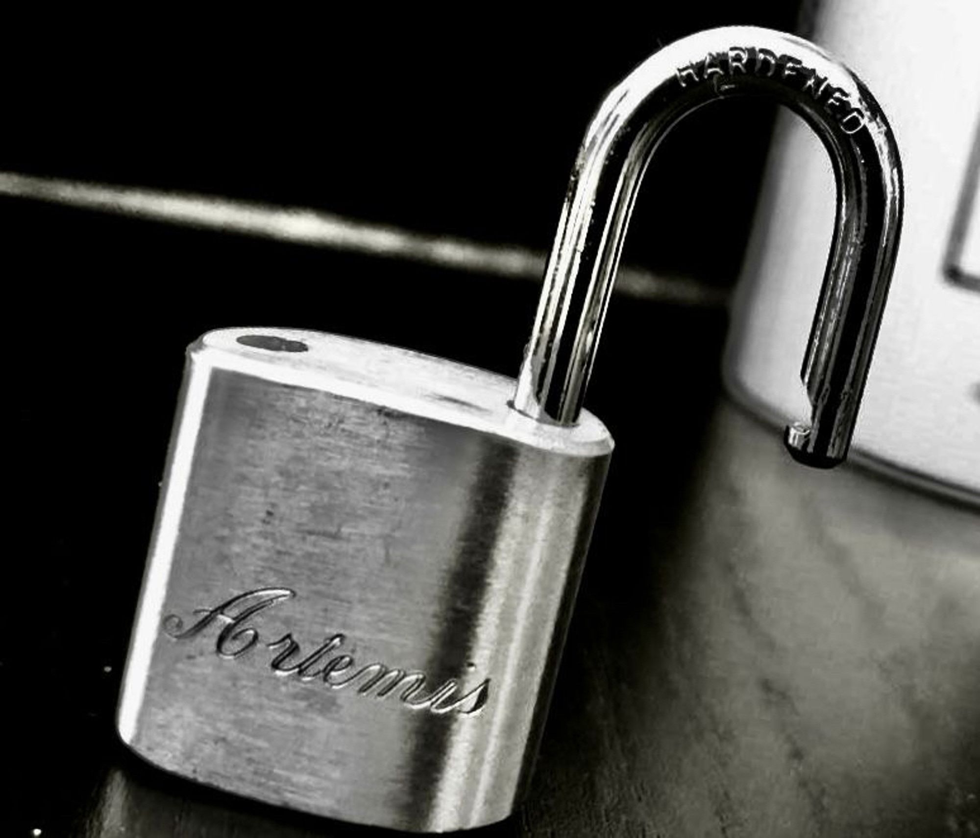 Black and white picture of a padlock which has „Artemis“ engraved