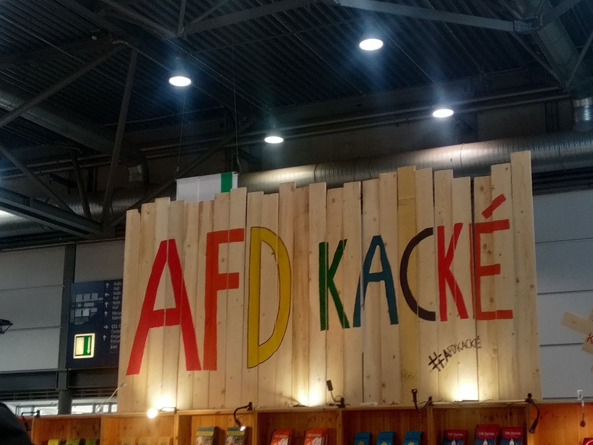 Stand von Correctiv auf der Leipziger Buchmesse, auf Holzbretter weithin in der Messehalle sichtbar steht: "AfD KACKÉ"