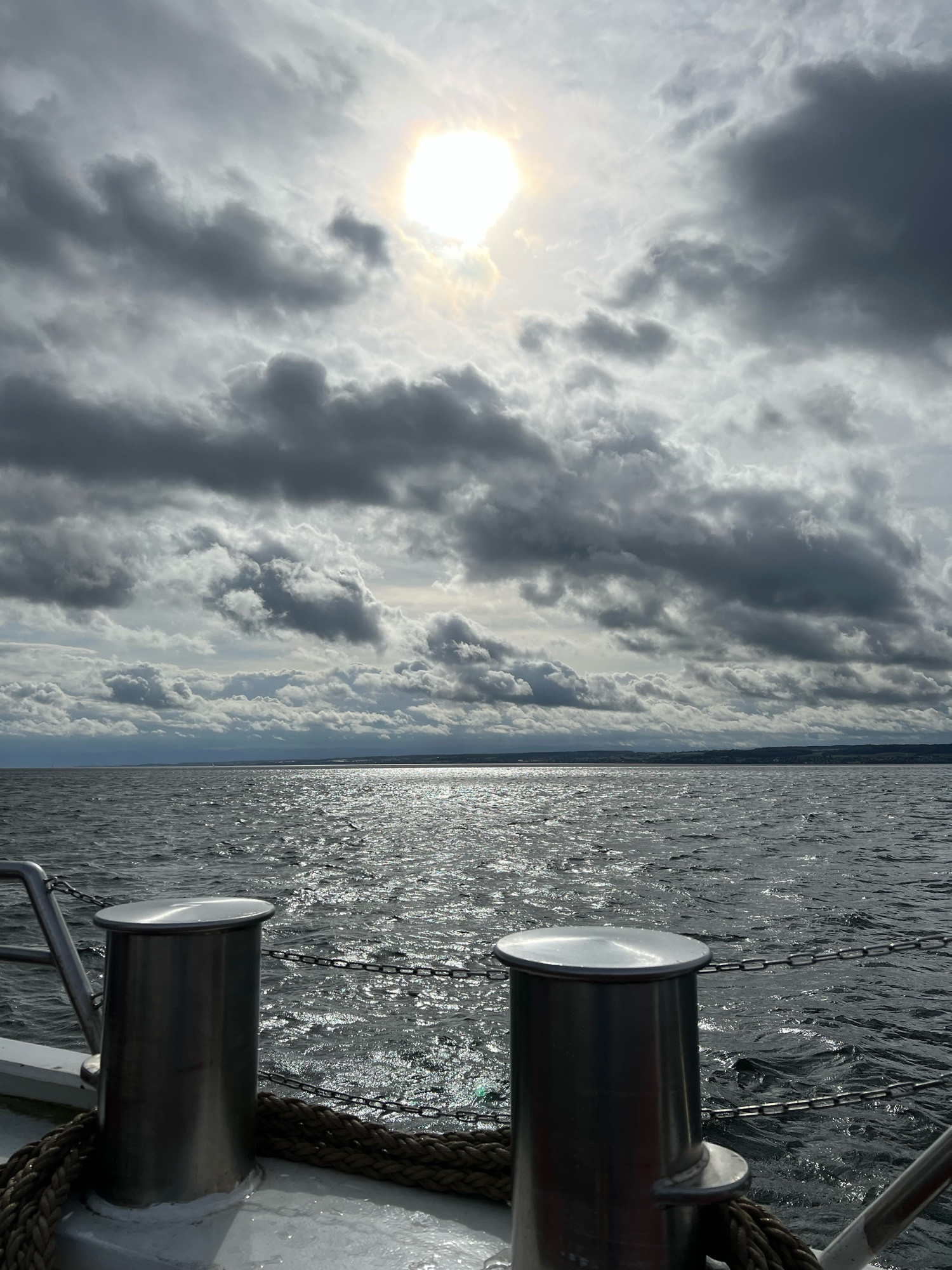 Blick von der Autofähre auf den Bodensee mit Wolken und Sonne