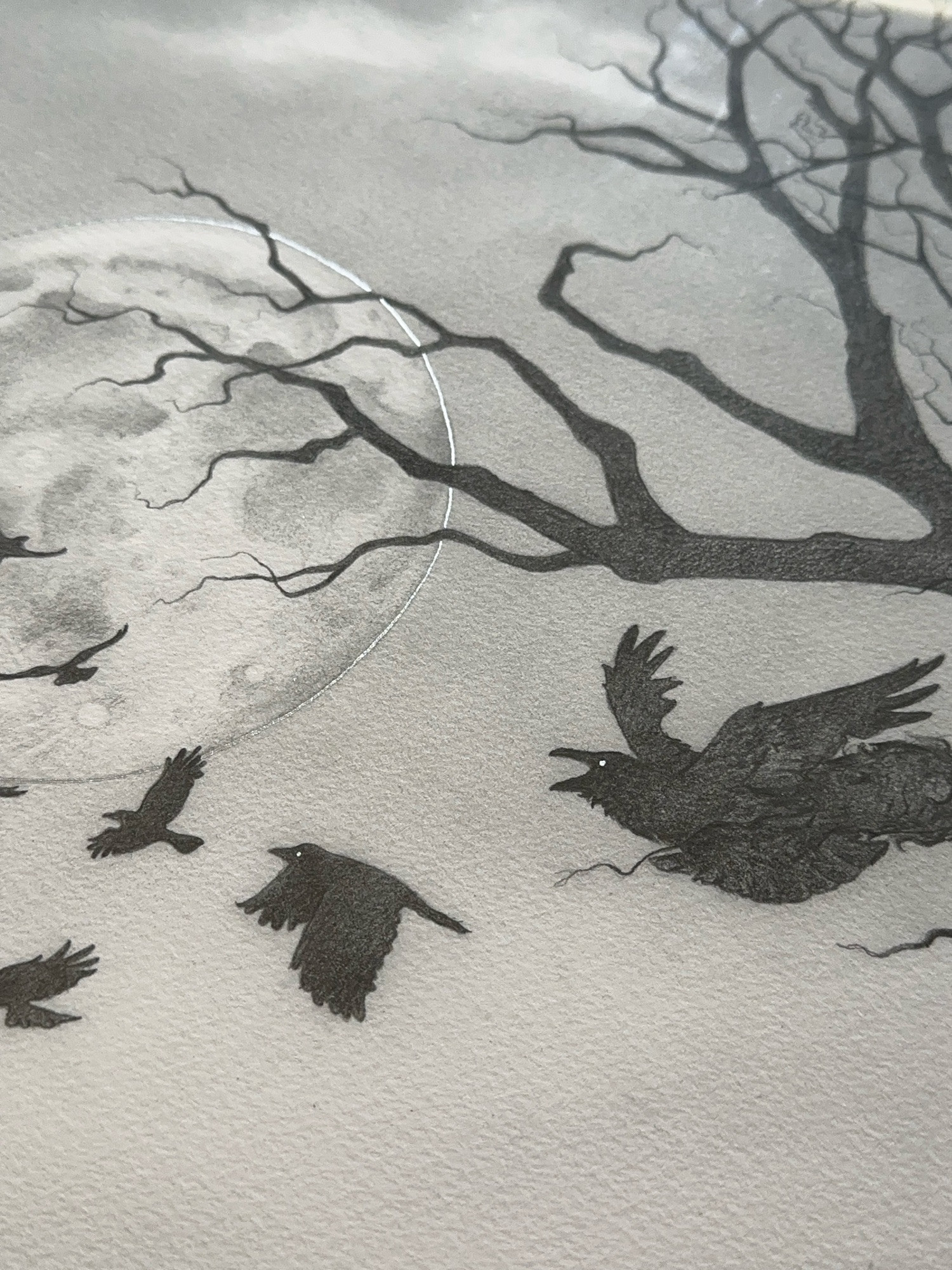 A close-up of a Moon Call print with the moon and crows embellished with silver