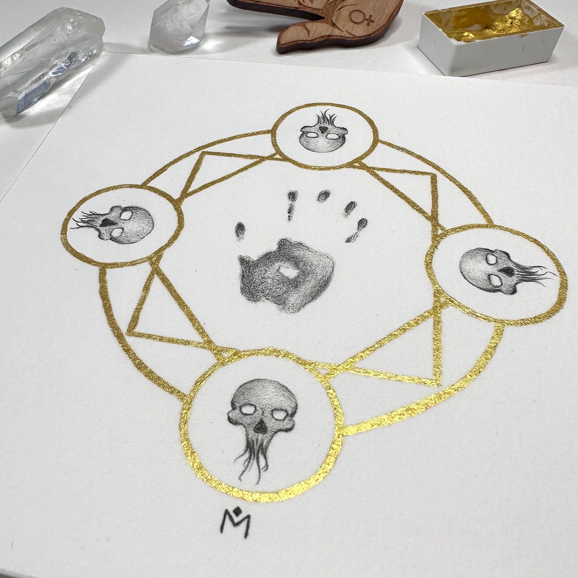 Gold magical circle with a handprint and skulls in graphite