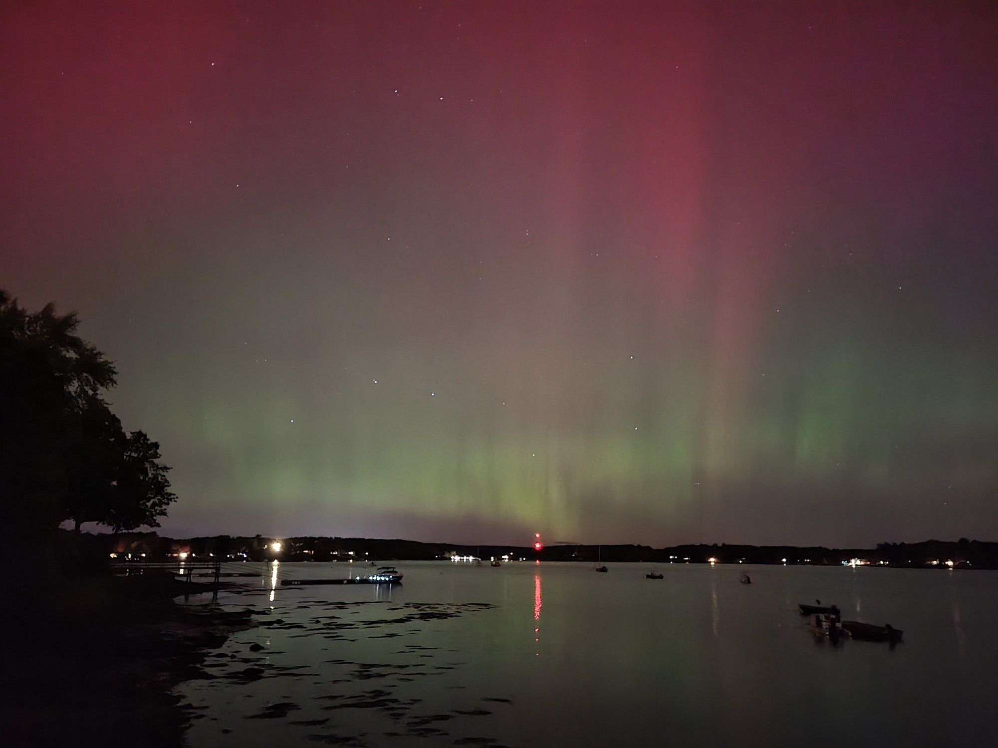 Picture of the aurora with red and green colors over a lake