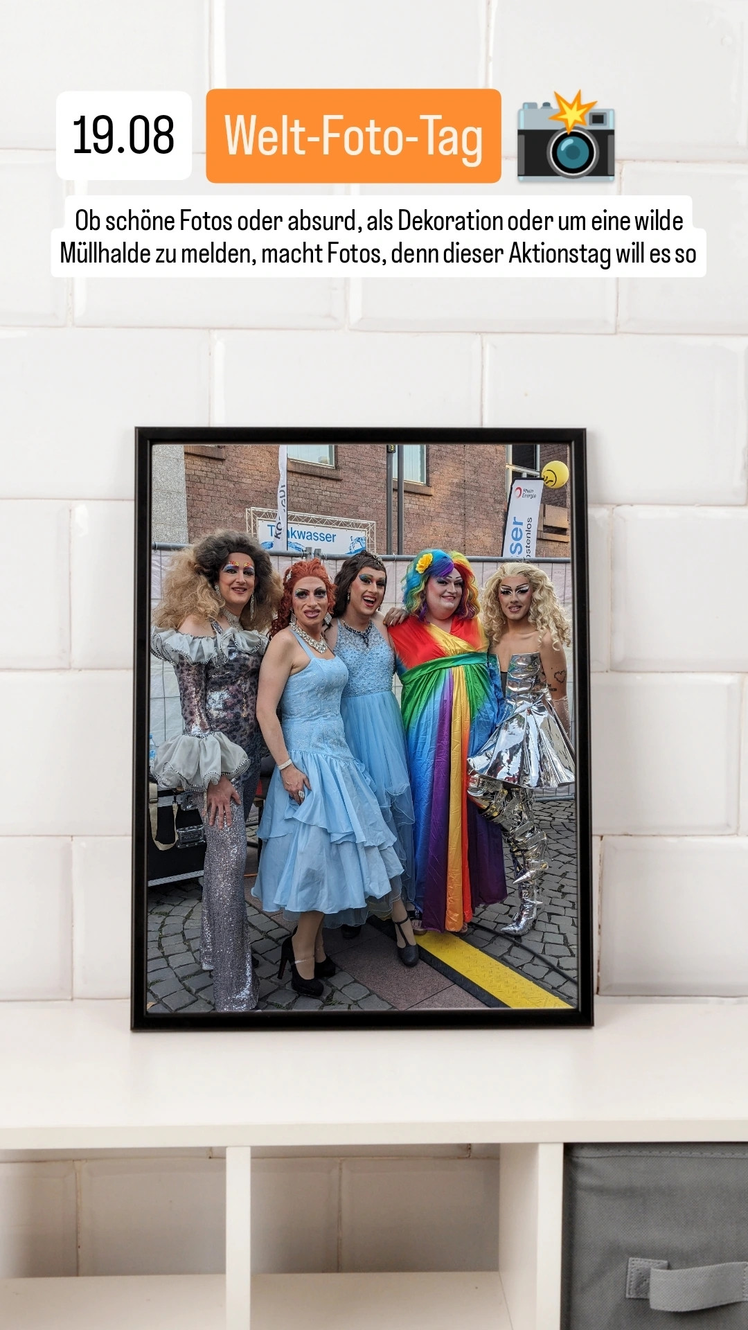 Ein Bilderrahmen auf einem Regal mit Foto von Drag Queens beim Colognepride.