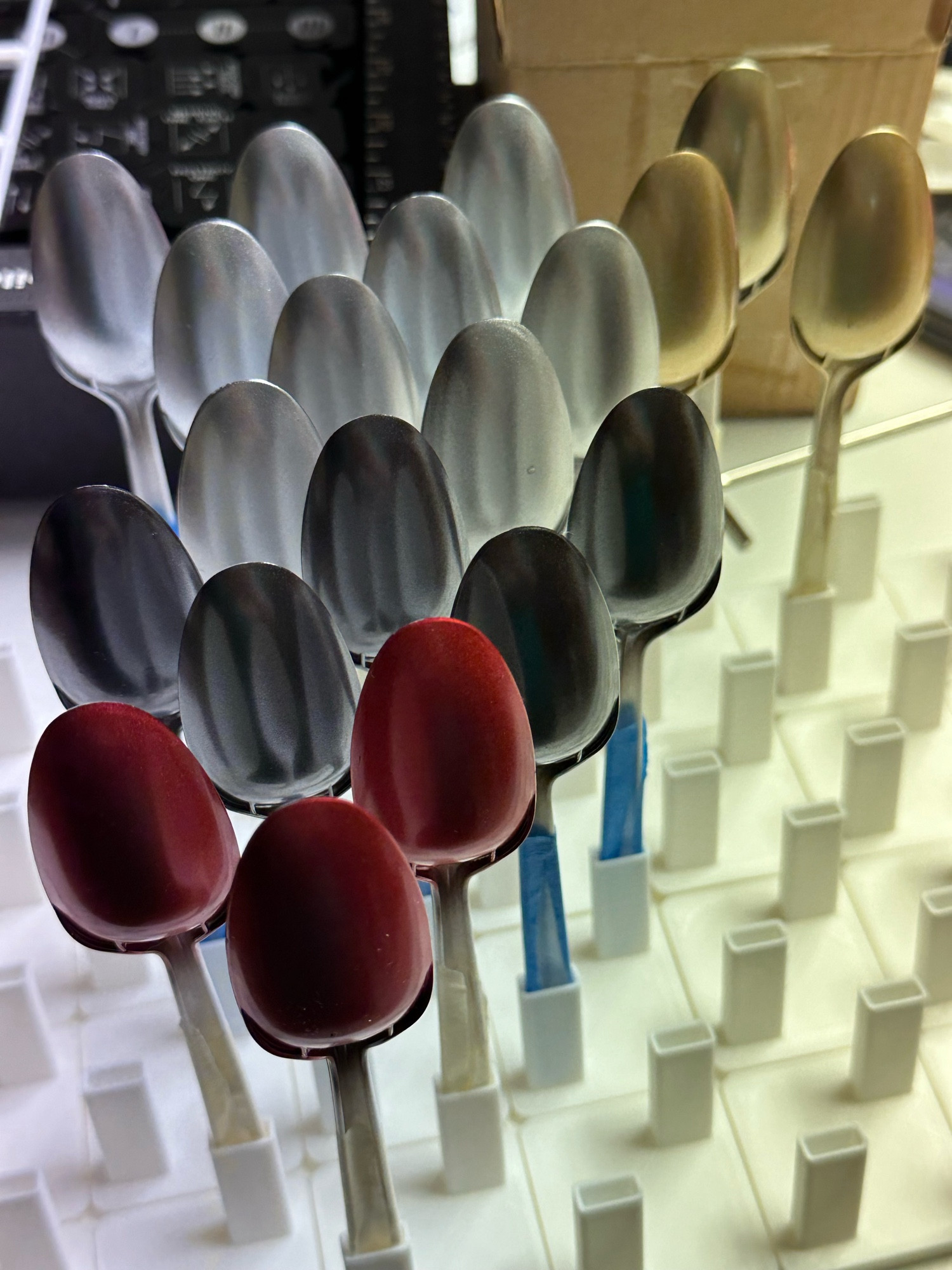 A photo of several airbrushed plastic spoons sprayed with GaiaNotes paints