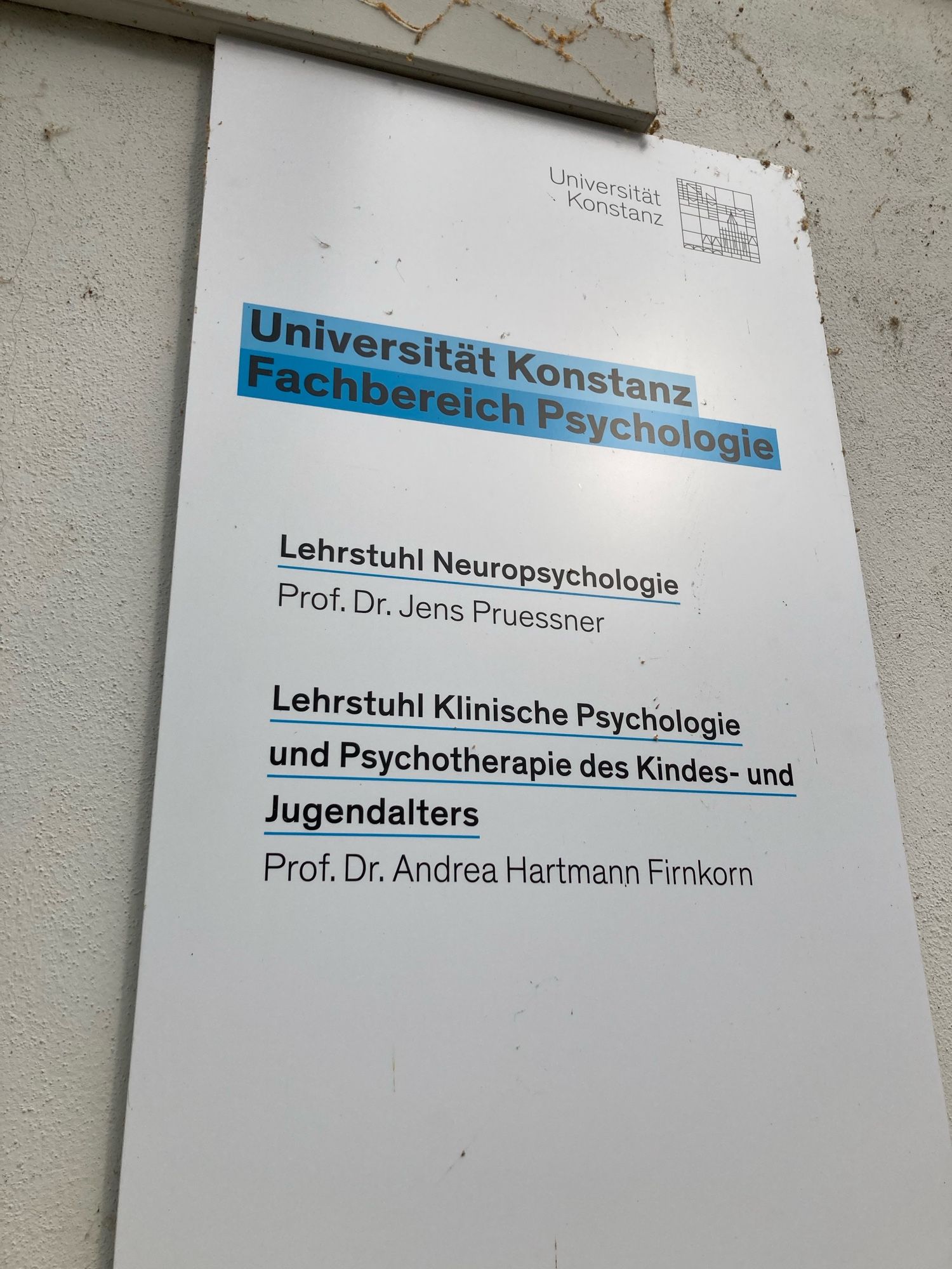 Schild Uni Konstanz mit Beschriftung Lehrstuhl Neuropsychologie (Prof. Pruessner) und Klinische Psychologie und Psychotherapie des Kinder- und Jugendalters (Prof. Hartmann Firnkorn)