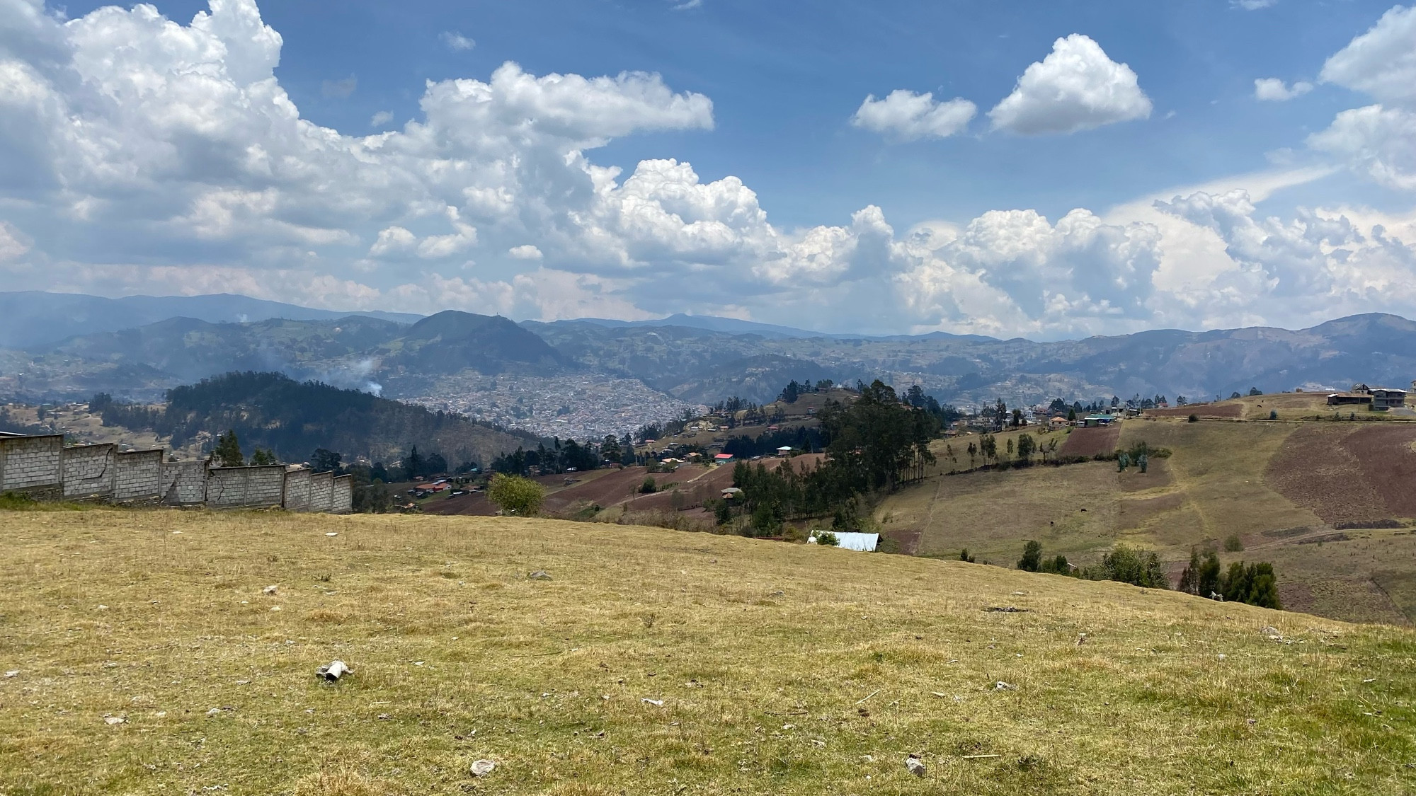 the town of azogues can be seen in the distance, nestled in the andes mountains 