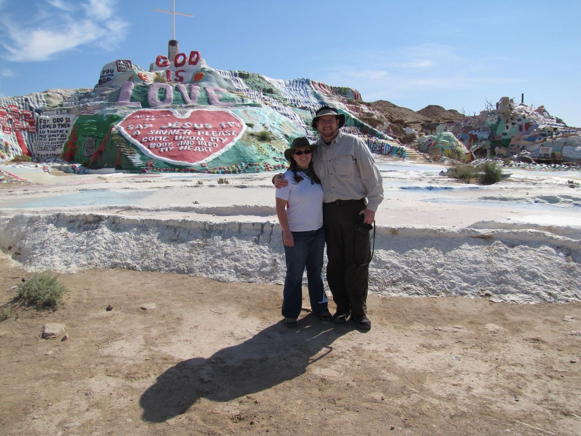 Me and my husband posing for a photo at Salvation Mountain, a manmade painted landscape created by one man as a massive art installation