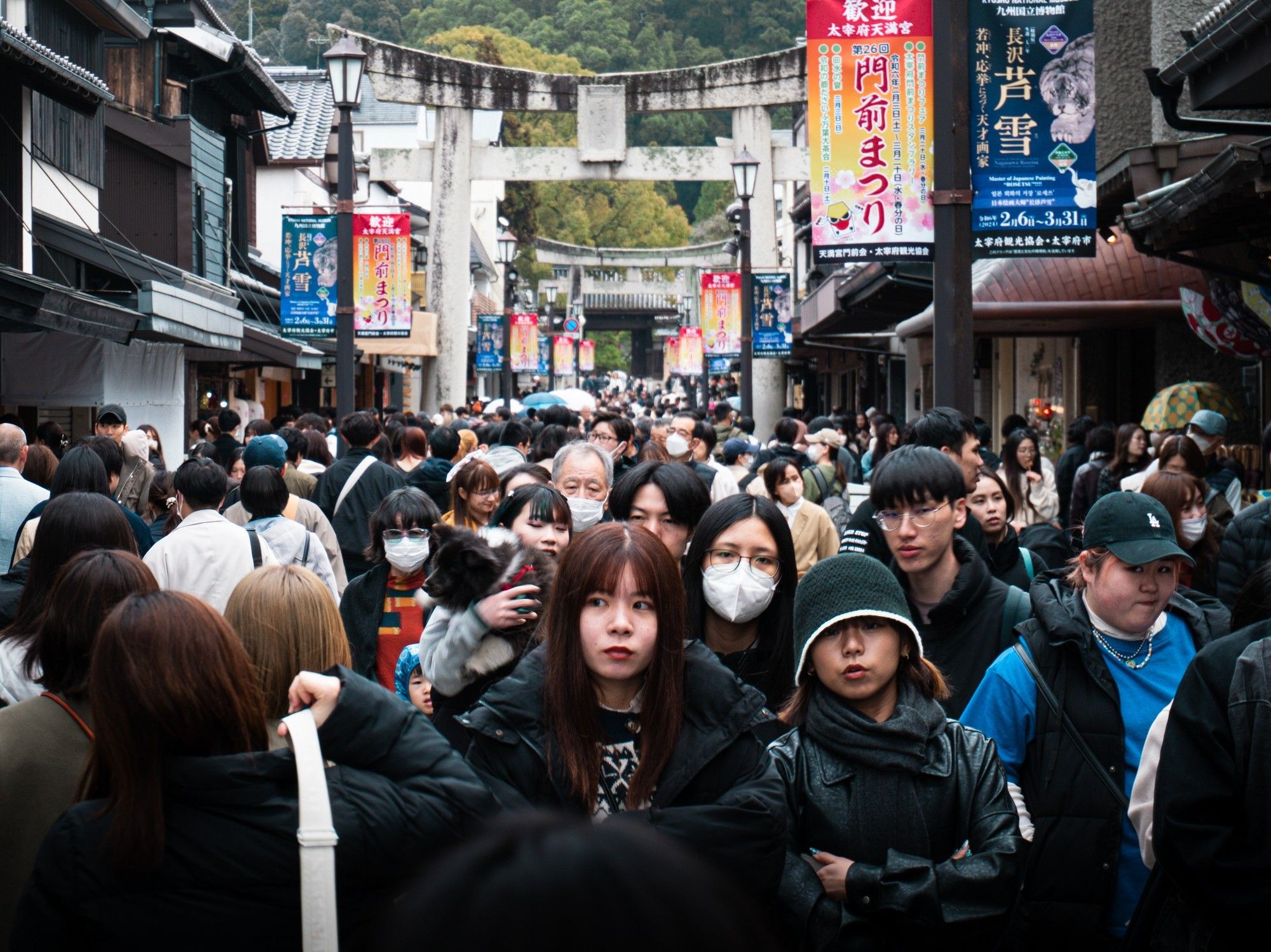 Multidão de pessoas na rua principal de Dazaifu, cidade próxima a Fukuoka. Japão, 2024. Foto em cores.