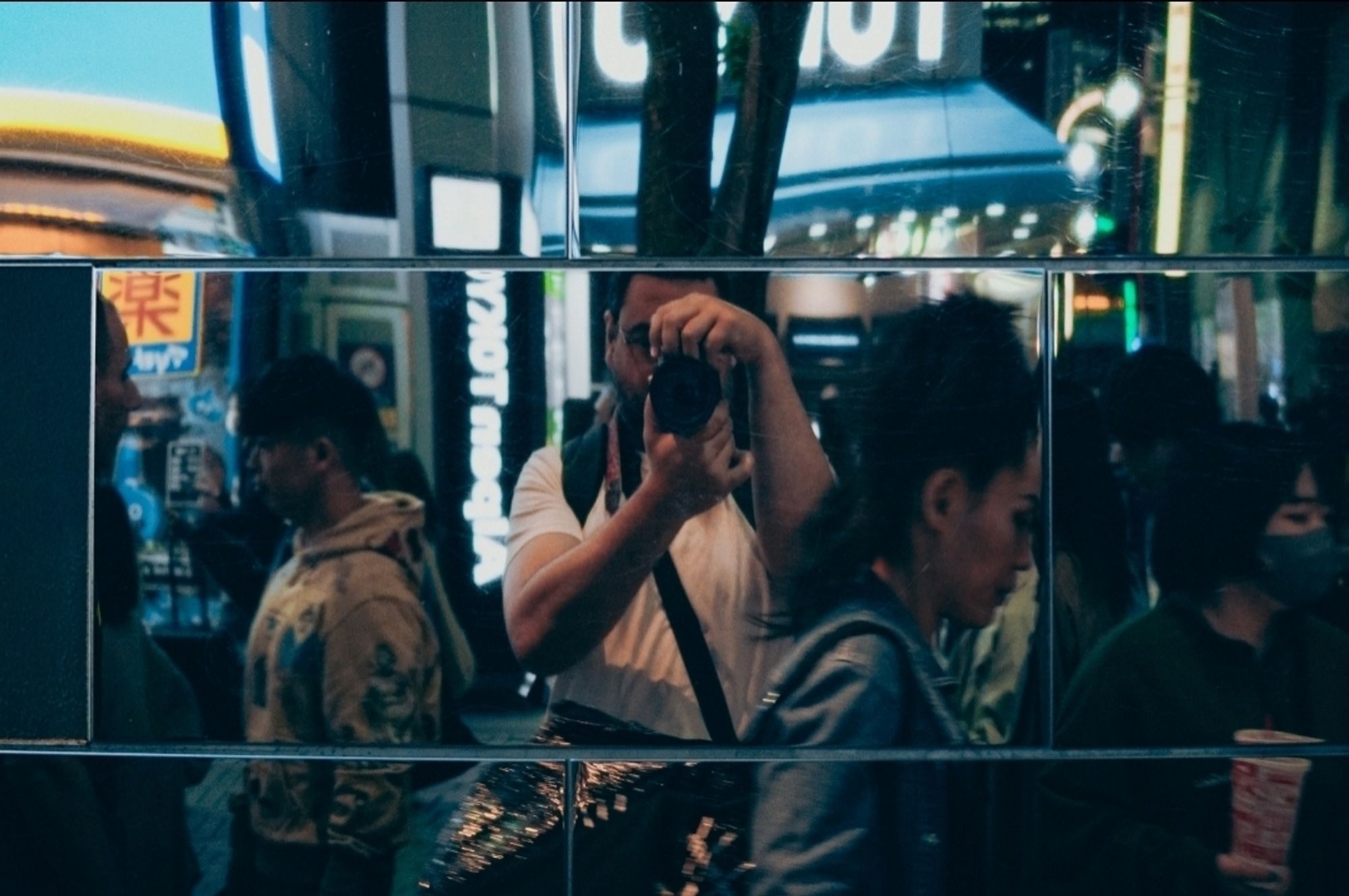 Autorretrato em meio à transeuntes com uso do reflexo de azulejos espelhados em Shinjuku - Tóquio, Japão, 2024.