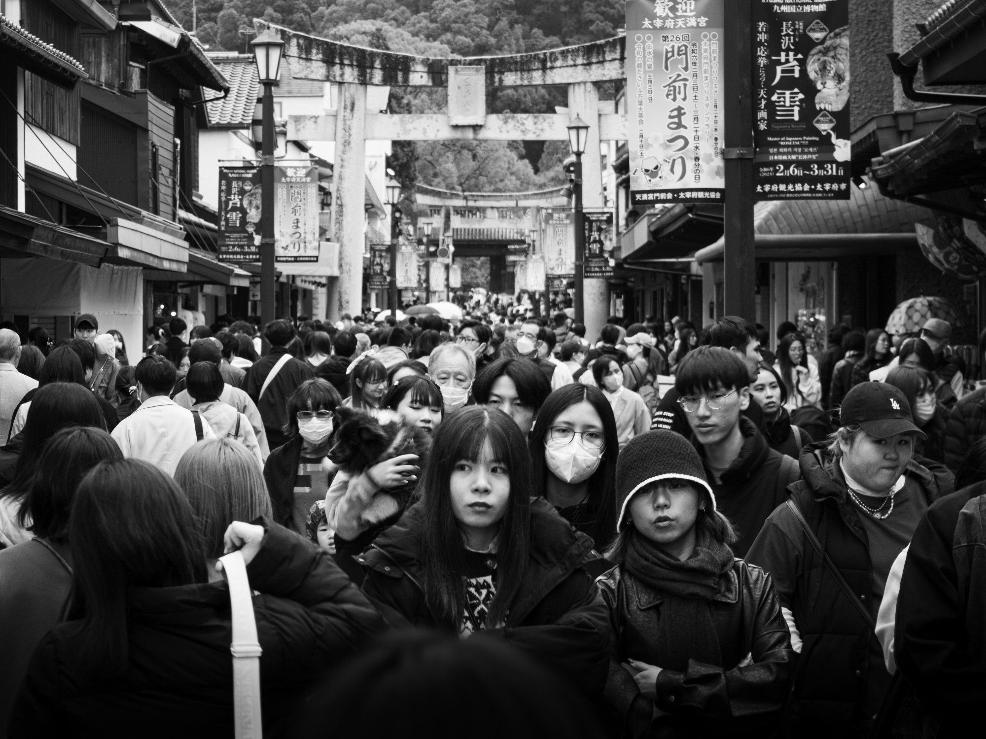 Multidão de pessoas na rua principal de Dazaifu, cidade próxima a Fukuoka. Japão, 2024. Foto em preto e branco.