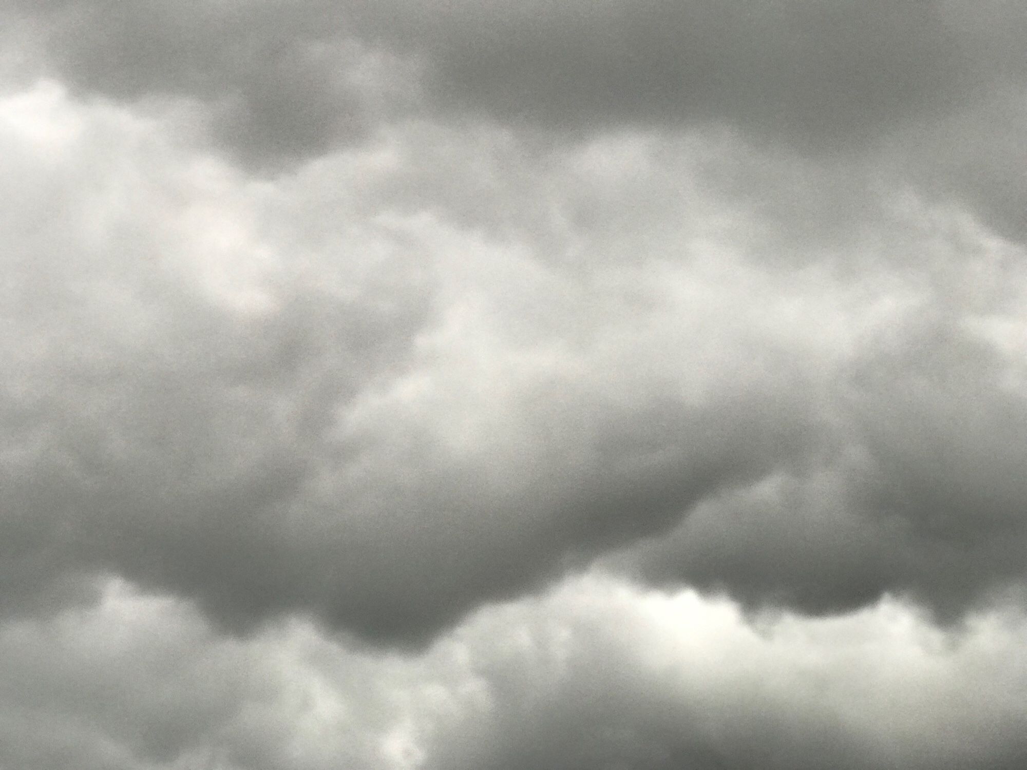 Black clouds like mountain ranges hanging Above the houses￼