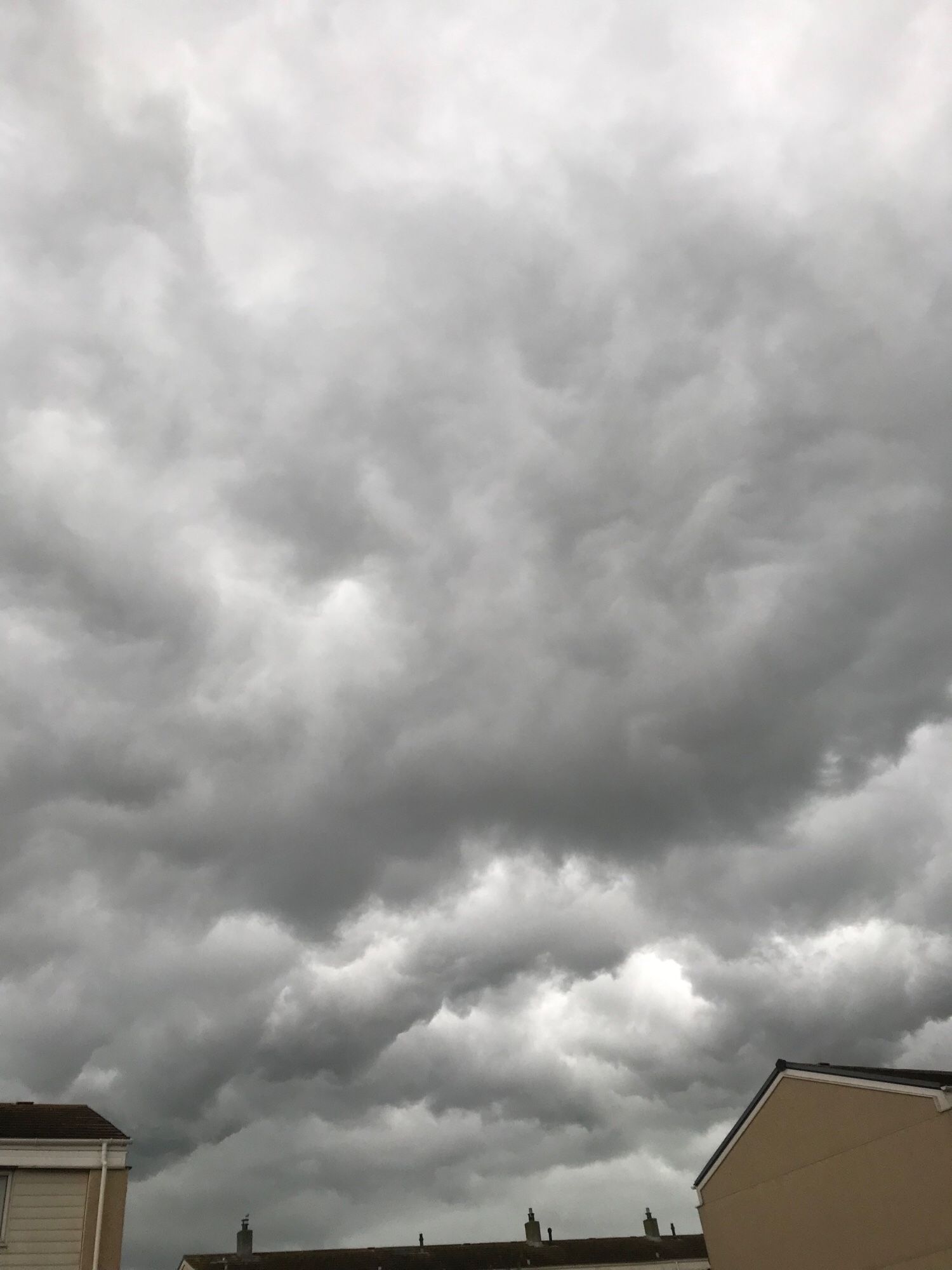 Black clouds billowing across the tops of houses