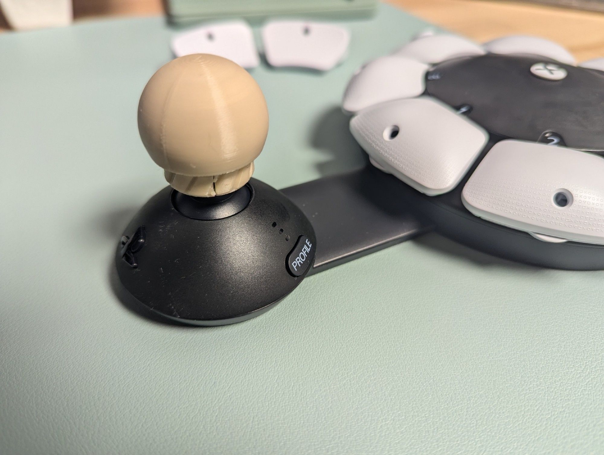 The joystick side of the PlayStation Access controller, with a ball shaped 3D printed topper attached.