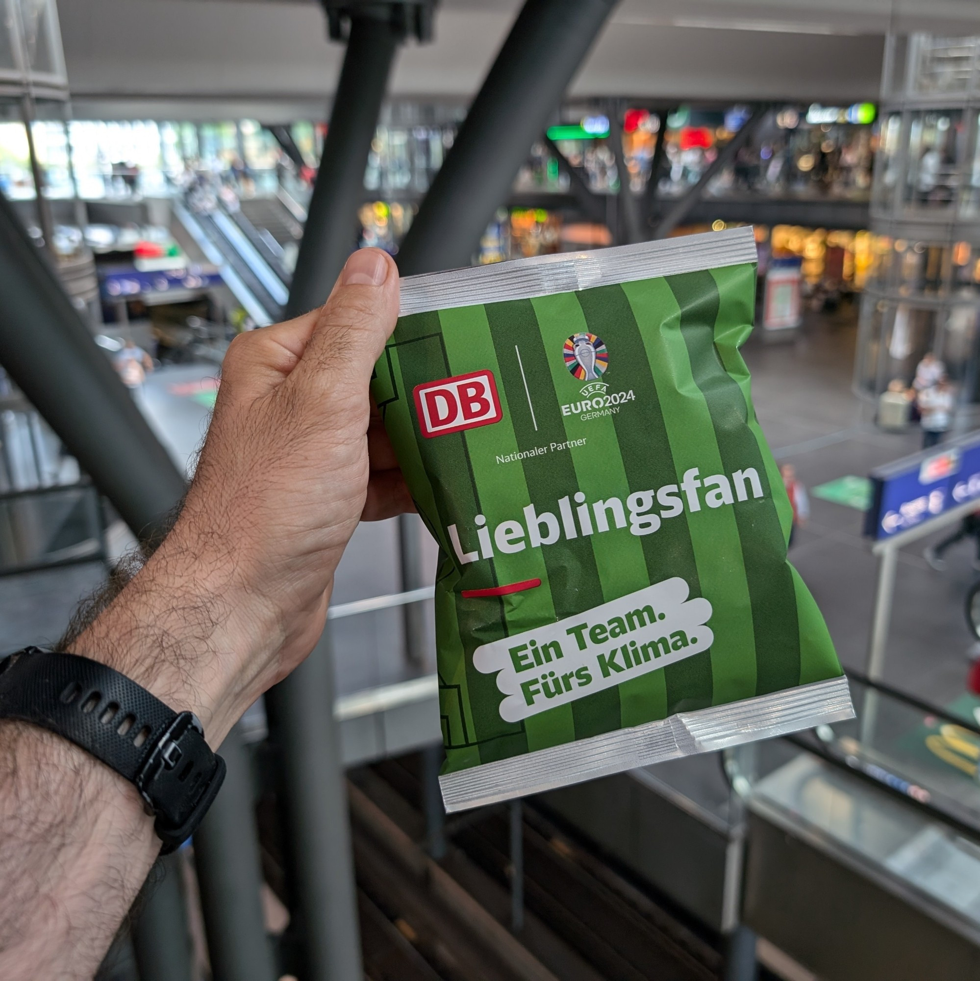 A photo of a football themed pack of crisps with Berlin Hbf in the background