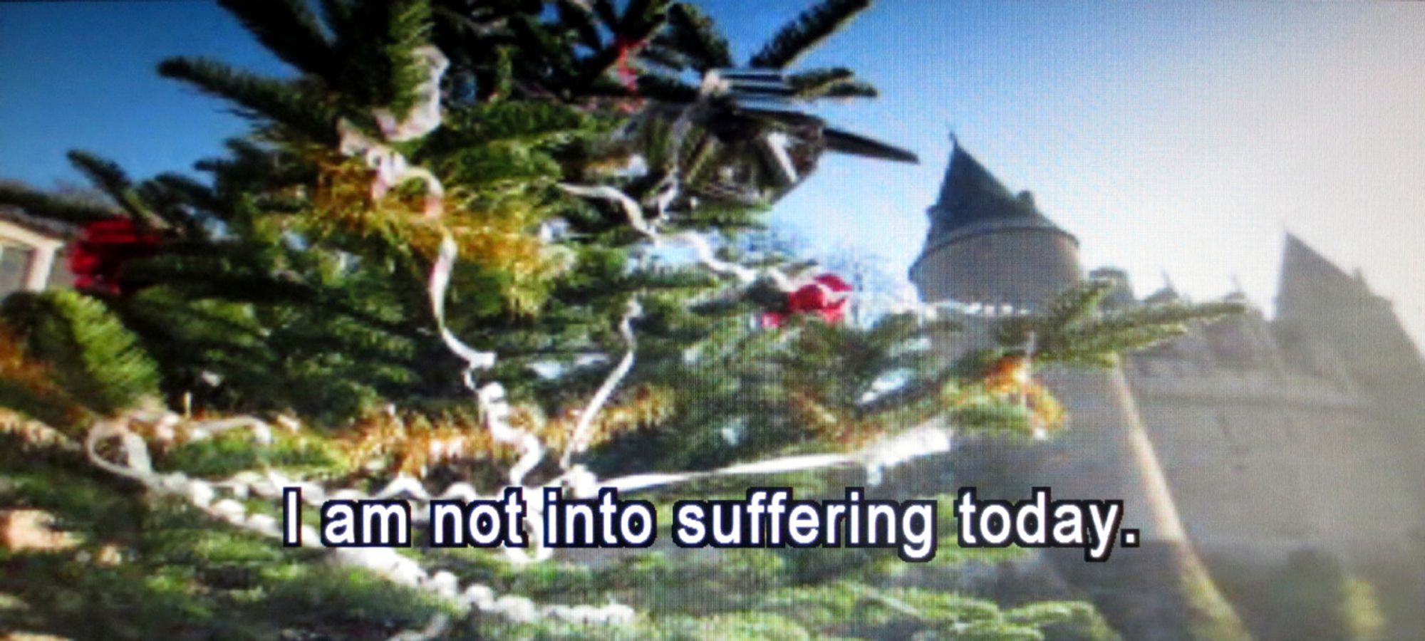 Plaatje met op de voorgrond een kerstboom en op de achtergrond een kasteel. Daar bovenop de Engelse tekst 'I am not into suffering today'.