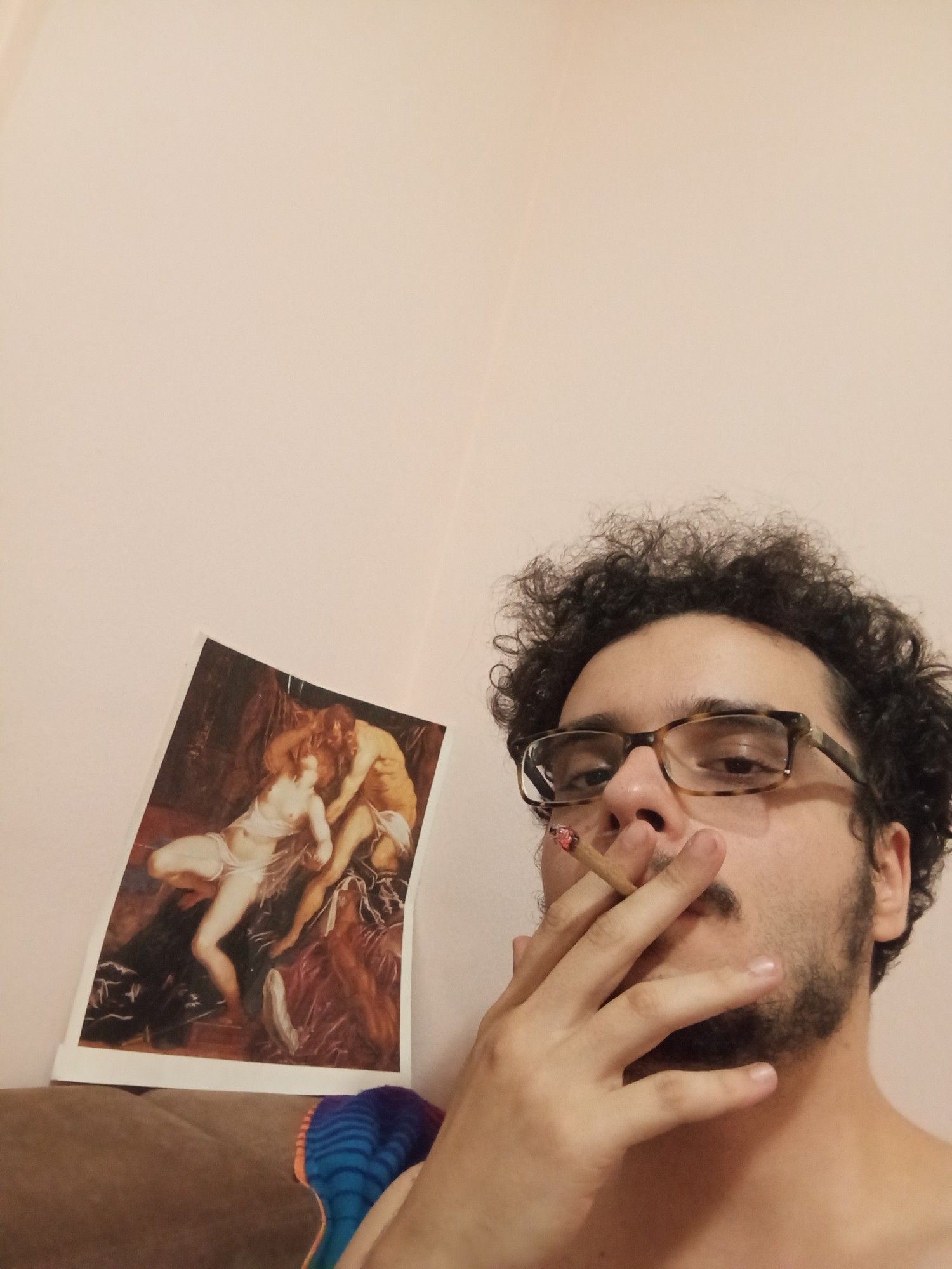 eu fumando aquele que deixou o Antonio Cândido com uma reprodução da obra Ticiano e Lucrécia do pintor maneirista veneziano Tintoretto ao fundo