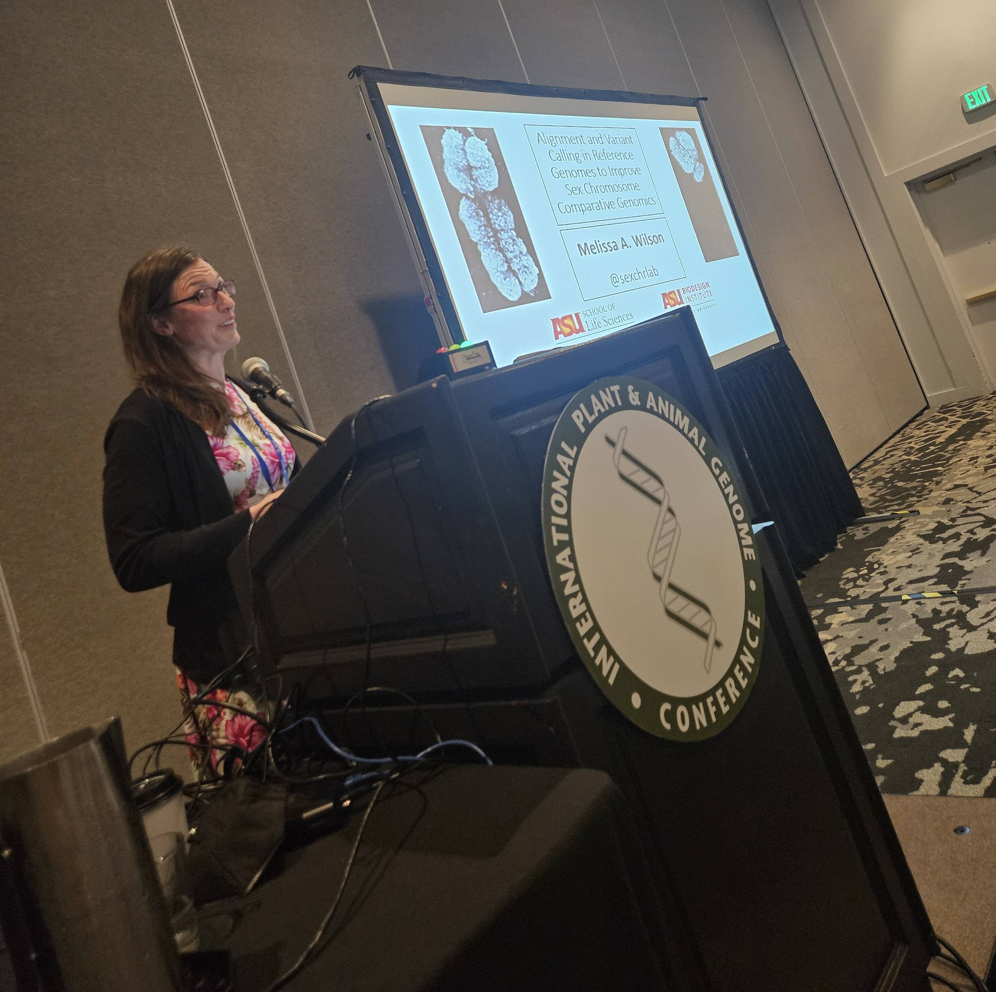 Dr. Melissa Wilson speaking at a podium at PAG31 introducing her talk entitled, "Alignment and Variant Calling in Reference Genomes to Improve Sex Chromosome Comparative Genomics"