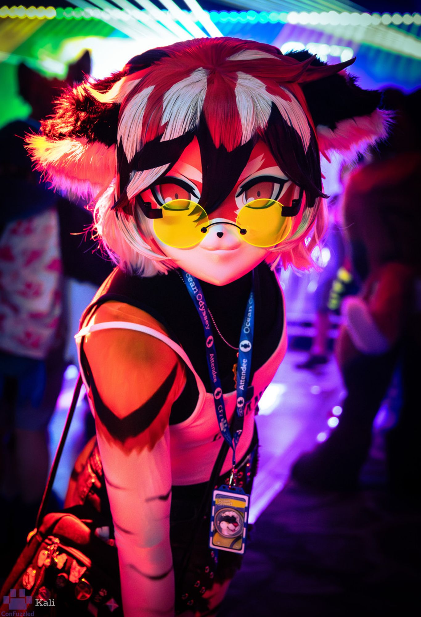 A photo of a kigurumi costume of Waai Fu, a tiger girl from the videogame Arknights. She is at a rave and looking directly at the camera, lit by neon light.