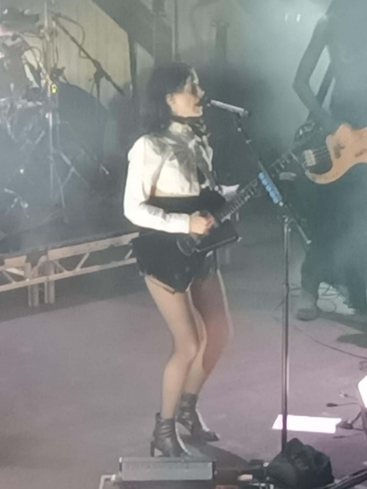 Annie Clark on stage playing guitar.