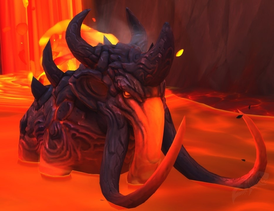 Screenshot from World of Warcraft. Shows a molten lava lake. With a lava fall (waterfall?) in the background. In the lake, is a magma mammoth. Has very thick, leathery skin. Tusks curl in a half circle. Trunk is glowing red. Has horns / spikes coming out of his back.