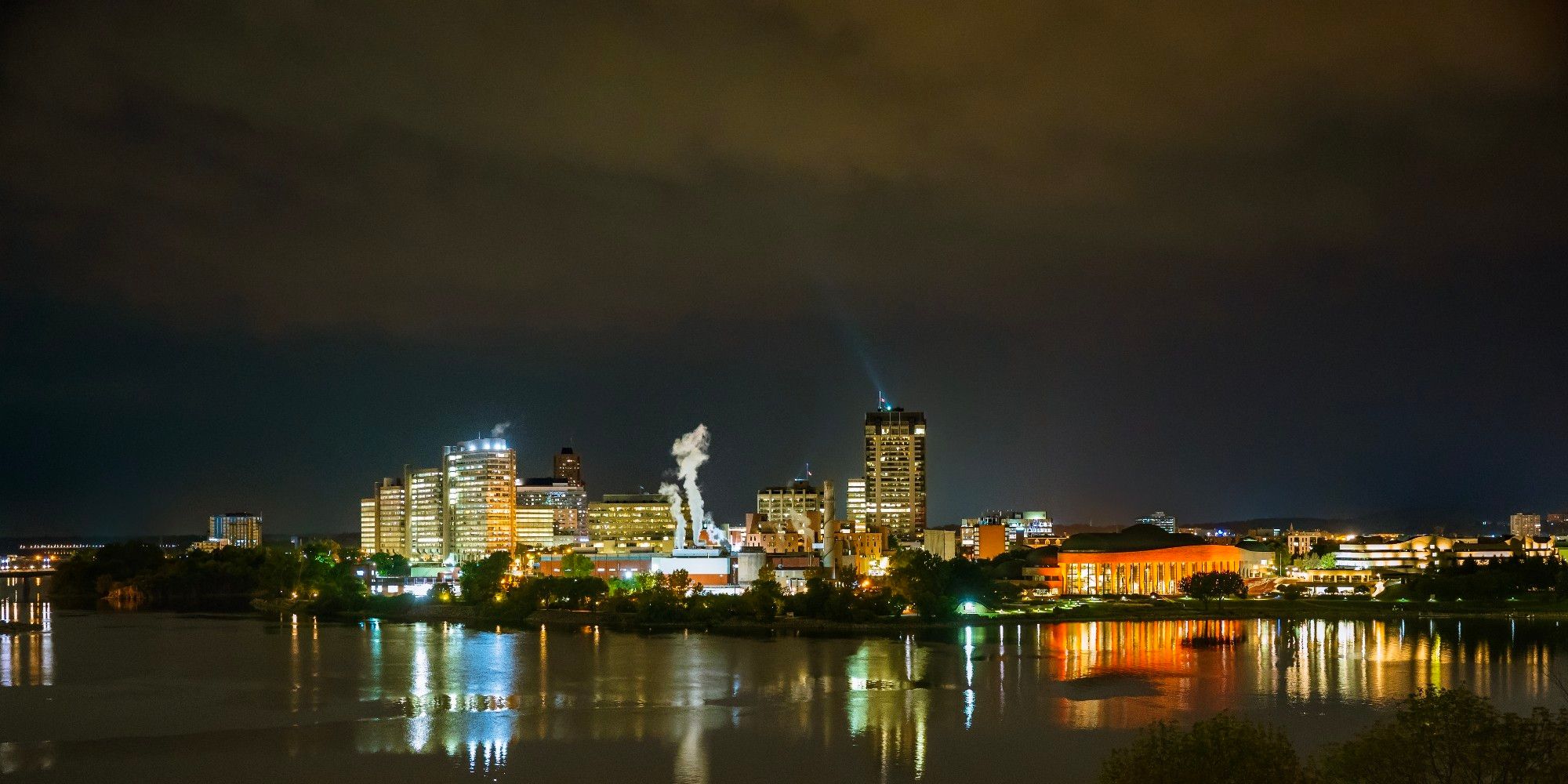 Panoramic long exposure night shot view of (Hull) Gatineau, Quebec skyline and shoreline of Ottawa River from Major's Hill Park, Ottawa Ontario Canada 
Captured by Komeil Karimi