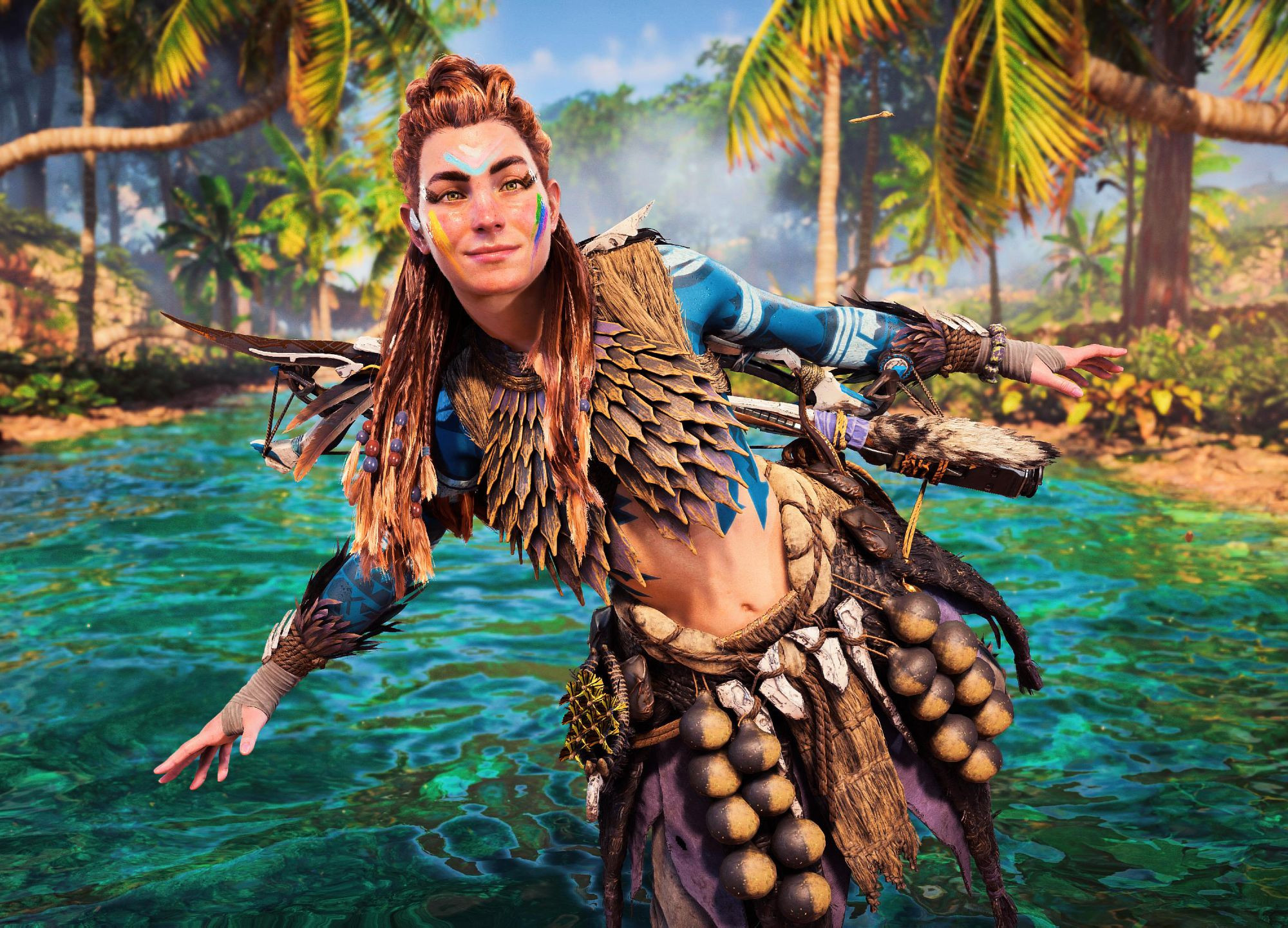 Aloy, standing in clear blue green waters, smiling at the camera, balancing on one foot.