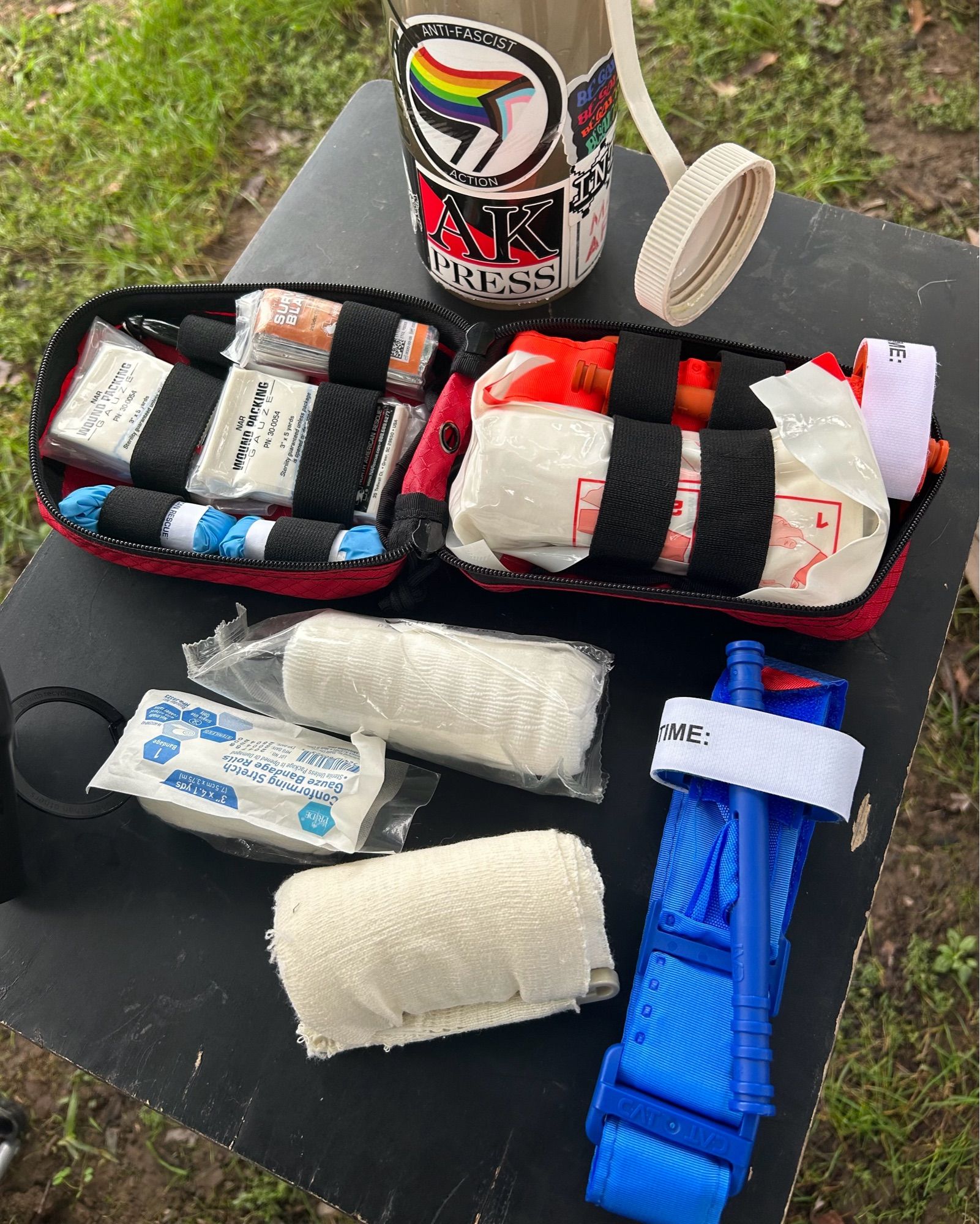 A photo of an IFAK on a table with gauze, tourniquet, and other supplies.