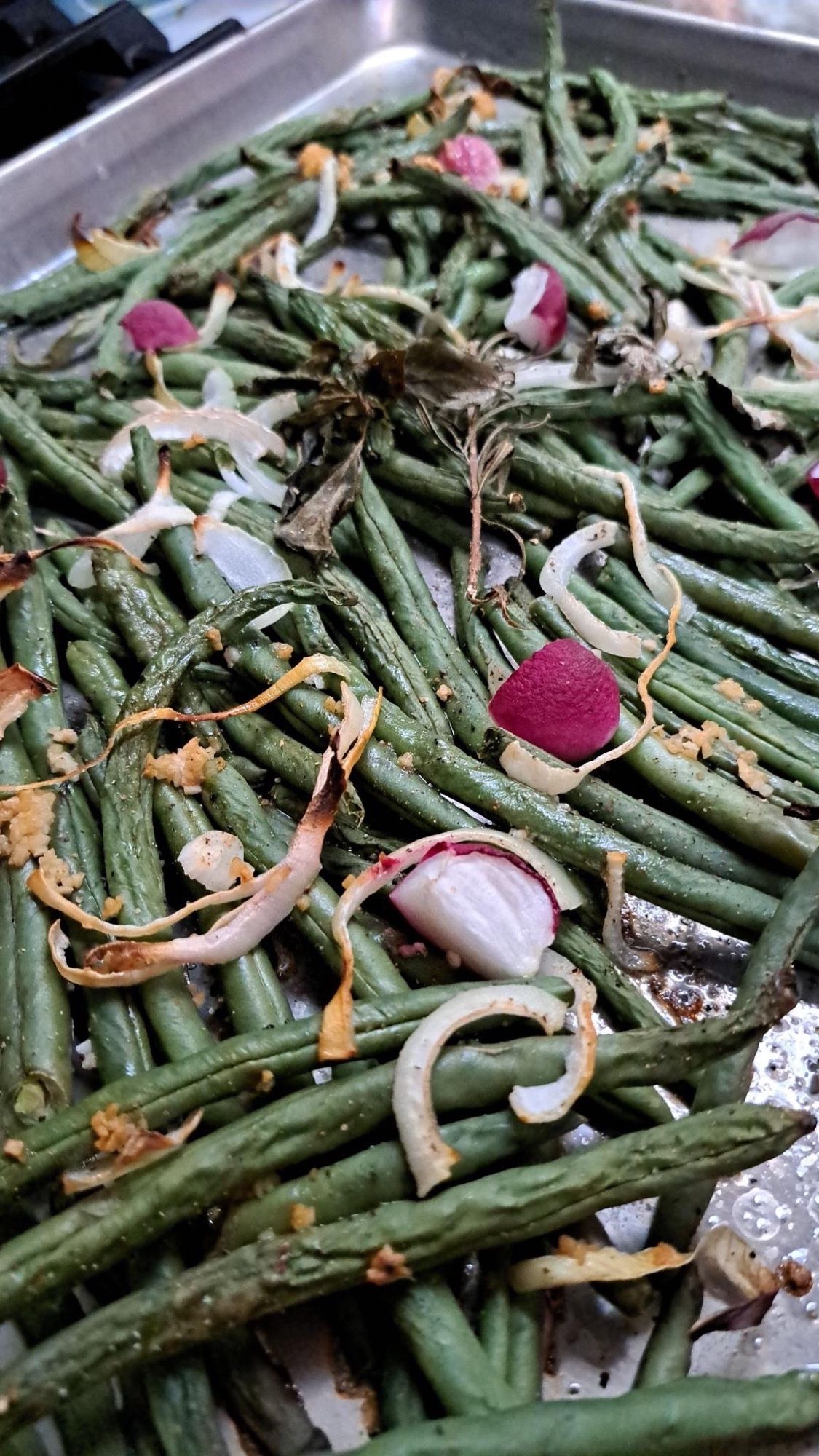 A sheet pan with roasted green peppers and onions