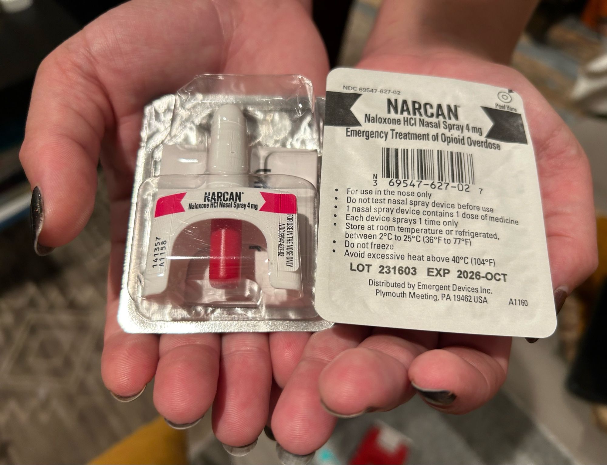 A photo of two Narcan nasal sprays in their packing in someone’s hands.