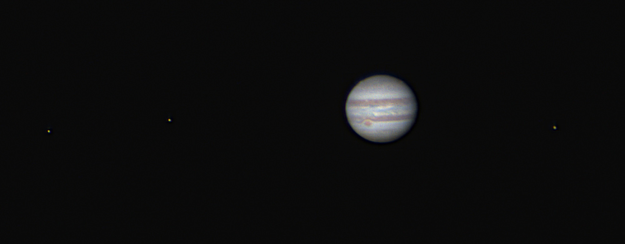 Jupiter and the Galilean Moons.  From left to right the moons are Europa, Io, Ganymede.  The great red spot is in the southern half of the planet. 