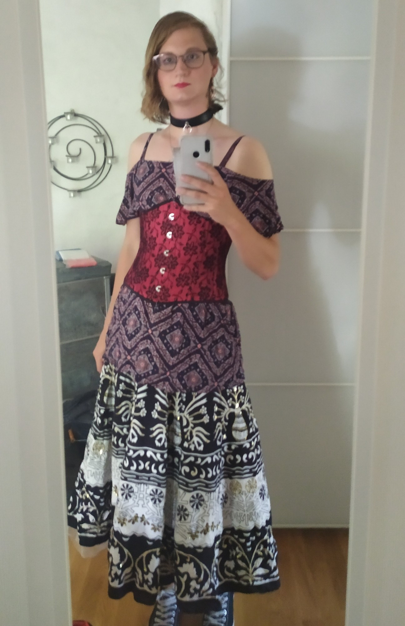 Mirror selfie of a girl wearing a black and red diamond patterned dress over a black and white skirt