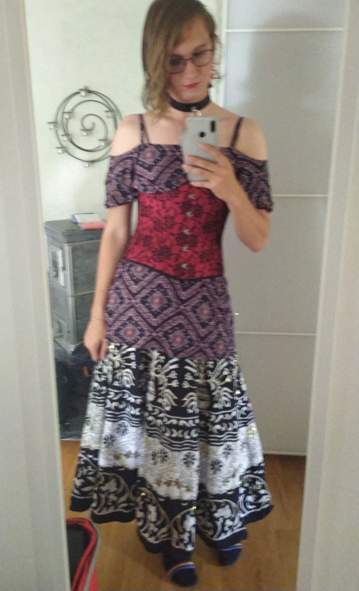 Mirror selfie of a girl wearing a black and red diamond patterned dress over a black and white skirt