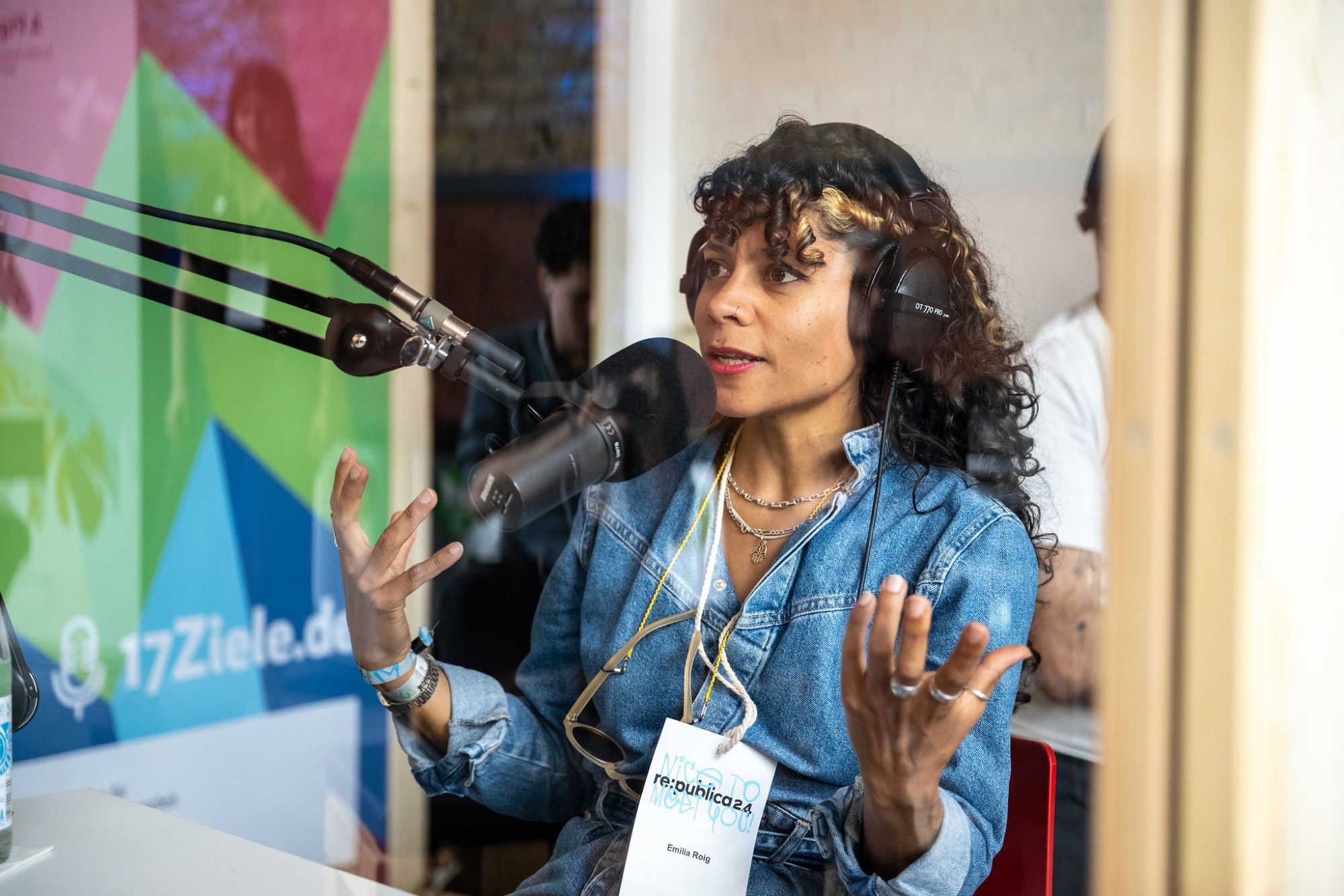 Foto: Stefanie Loos. Die Aufnahme zeigt Emilia Roig im Podcast-Booth auf der re:publica 24. Sie spricht in ein Studiomikrofon.