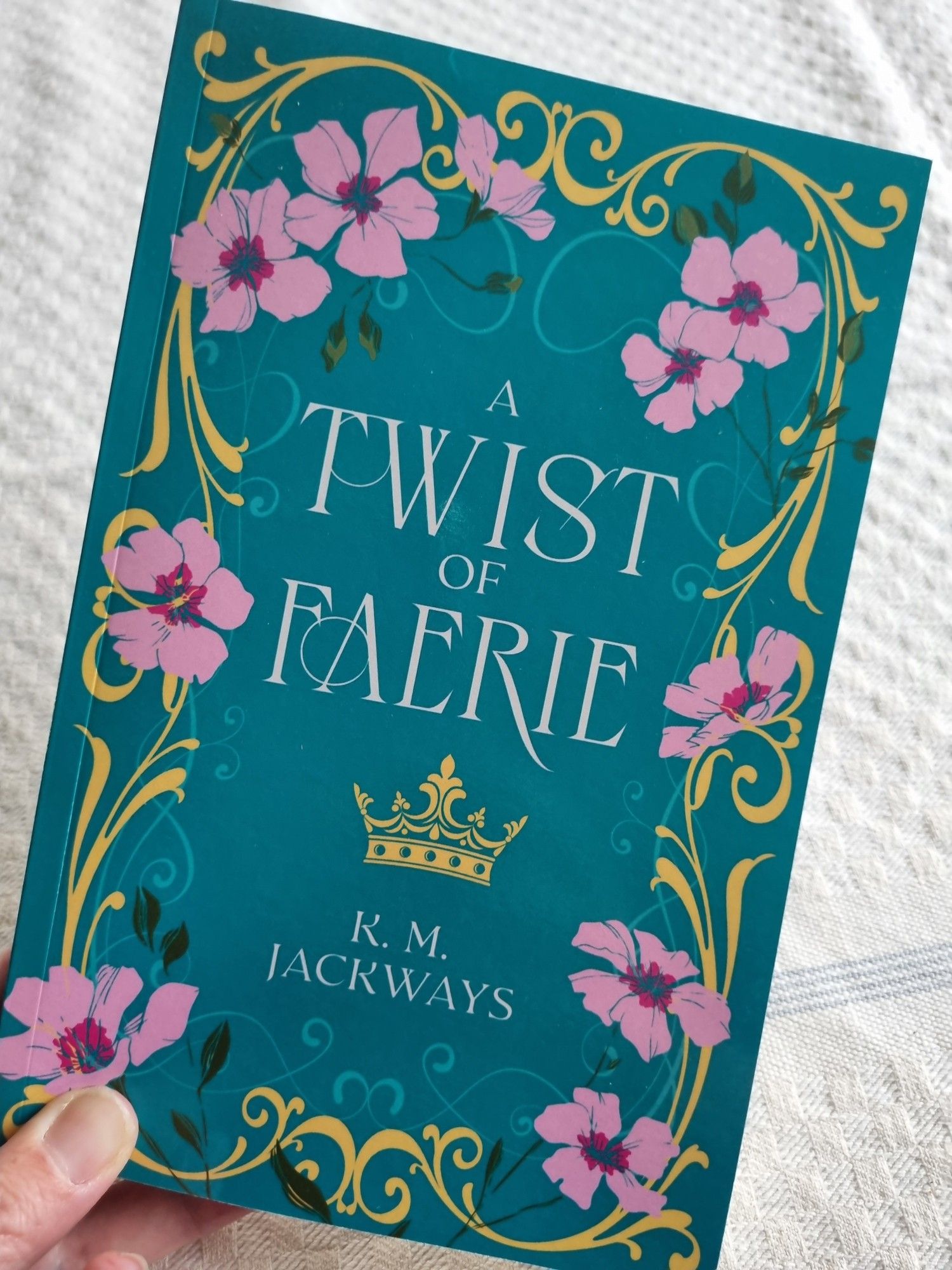 Green book cover of A Twist of Faerie with vines and pink flowers