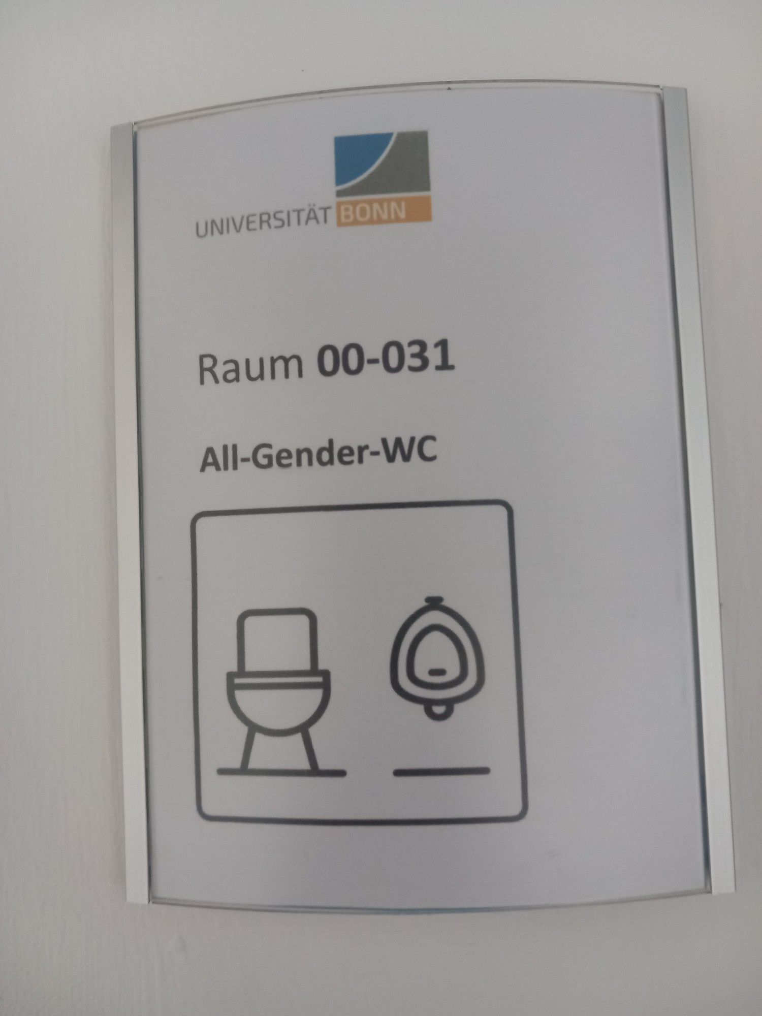 Schild: 
UNIVERSITÄT BONN

Raum 00-031

All-Gender-WC
Piktogramm WC und d Urinal