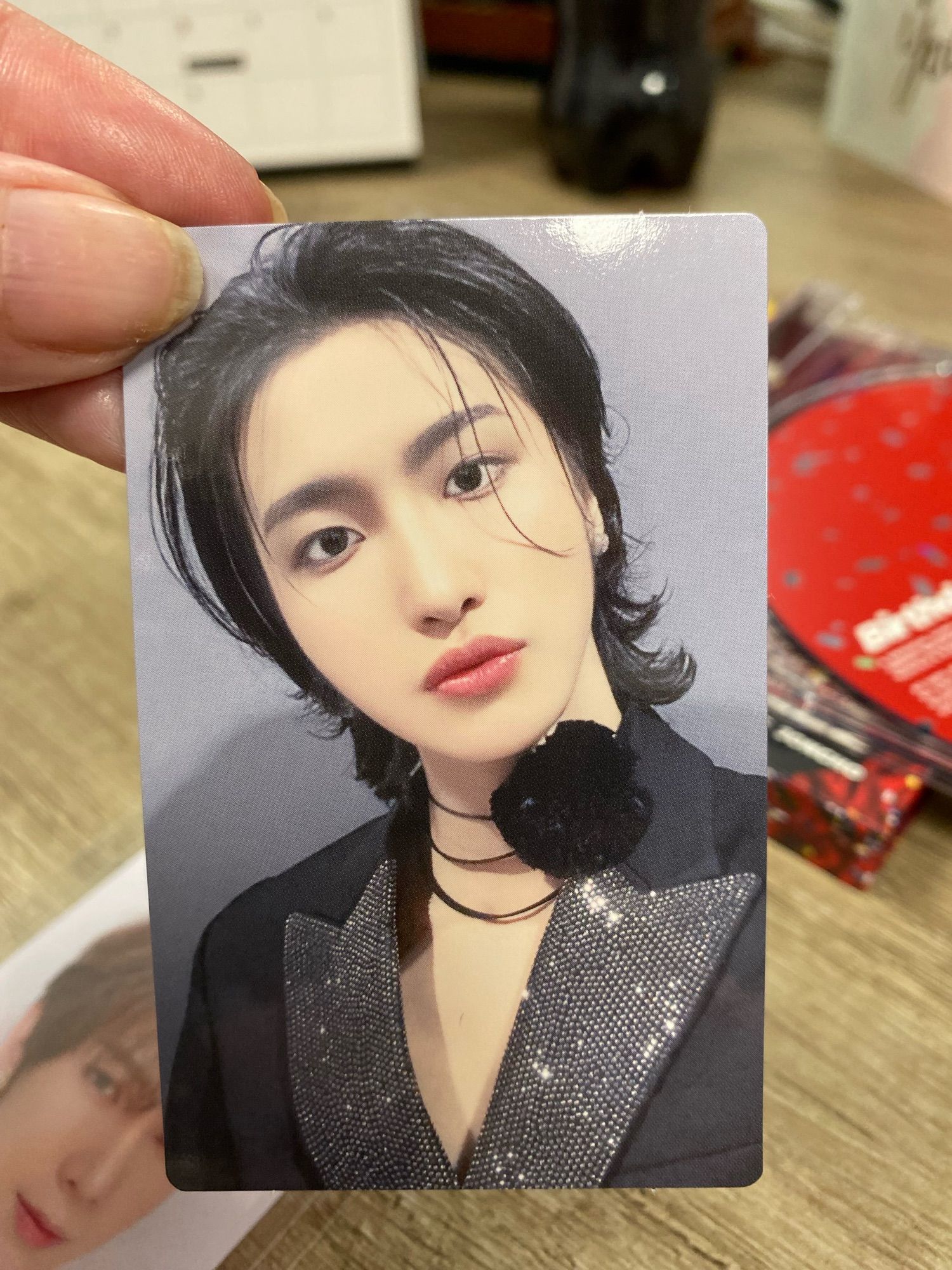 The most beautiful Seonghwa photocard I now own. He’s got a thin silver choker around his neck with a black rose attached to it and he’s wearing a black jacket with a sequinned lapel