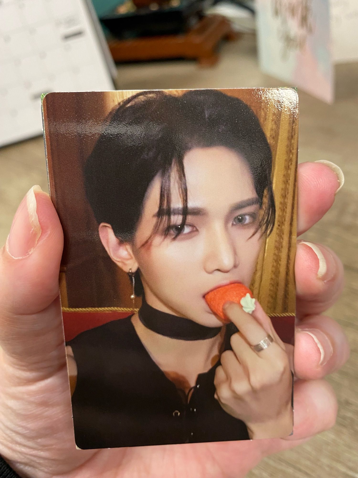 A Yeosang photocard where he is biting a strawberry