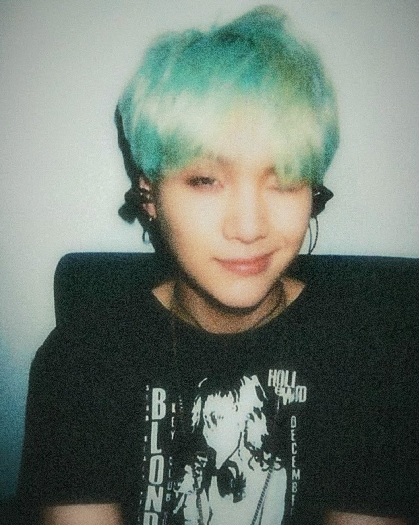 Min Yoongi aka Suga of BTS winking and smiling cutely, had iconic mint color hair wearing a black t-shirt necklace and earbuds