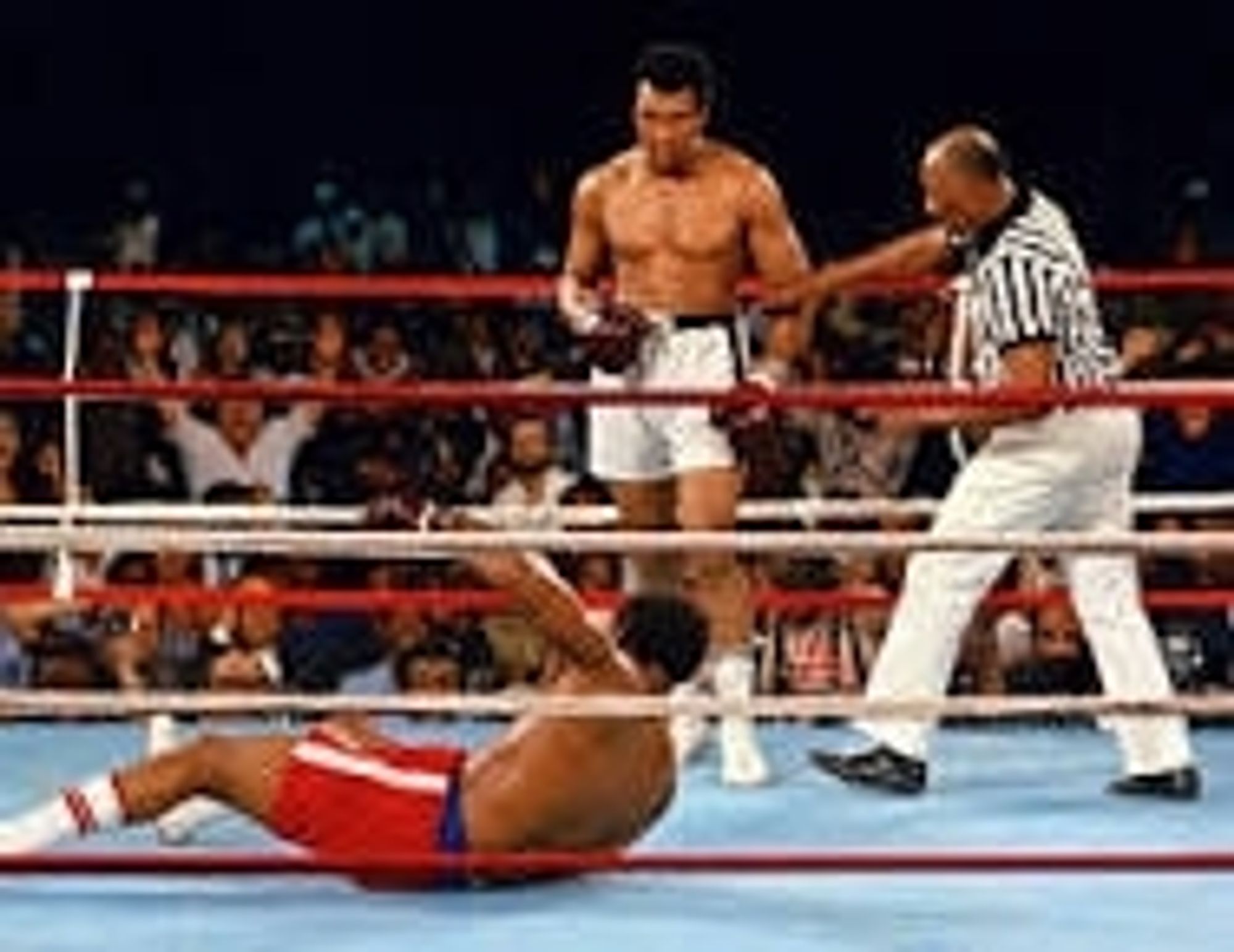 Mohammed Ali standing over a prone George Foreman at "The Rumble in the Jungle"