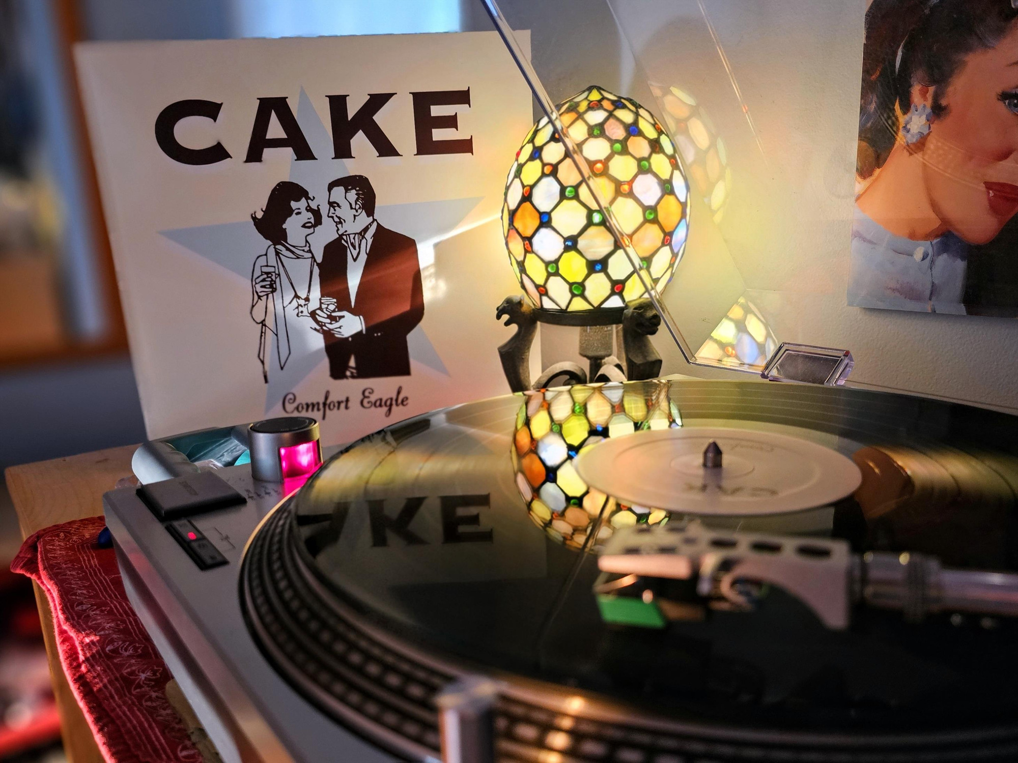 A turntable spinning "Comfort Eagle" by Cake, with the LP sleeve displayed 