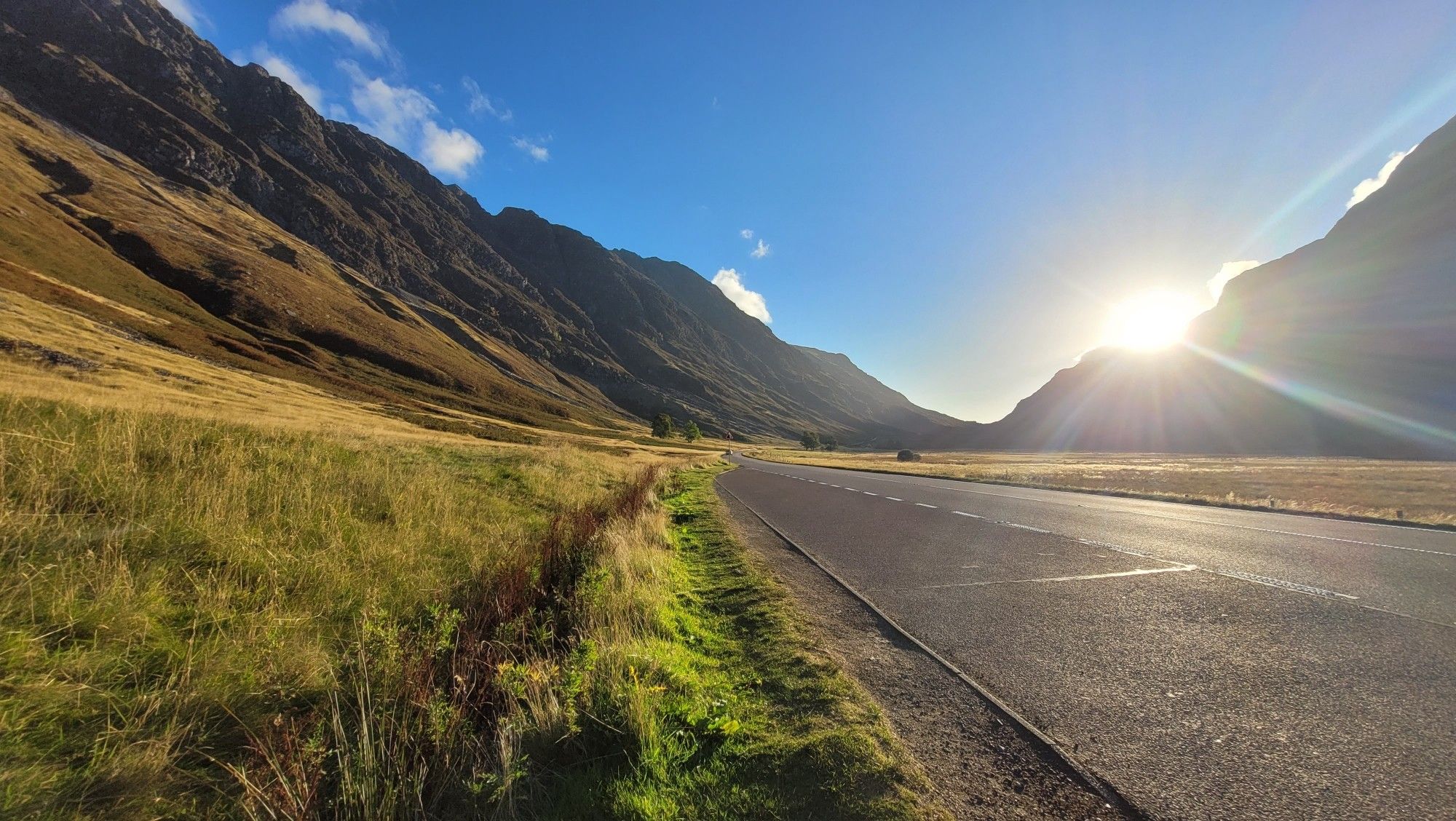 Glen Coe with sun coming up behind it's mountains.