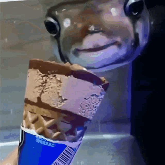 a gif of a fish attempting to eat ice cream, but it is unable to as the icecream is being held outside the tank and behind the glass, meaning the fish will never be able to reach it