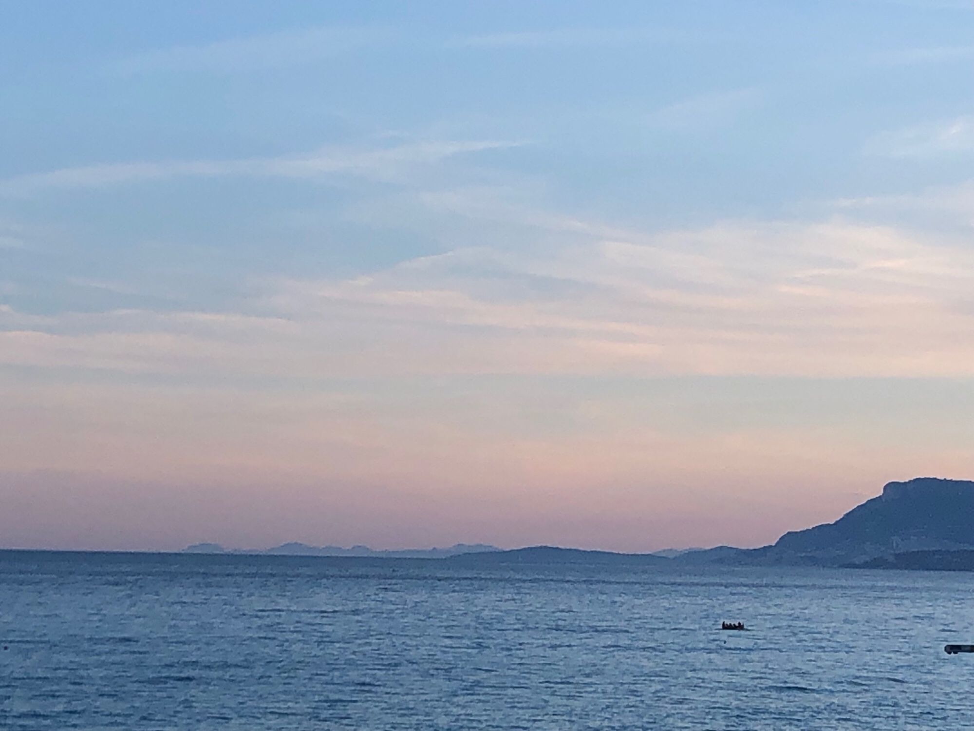 Näher gezoomt. Ein kleines Boot mitten auf dem Meer.