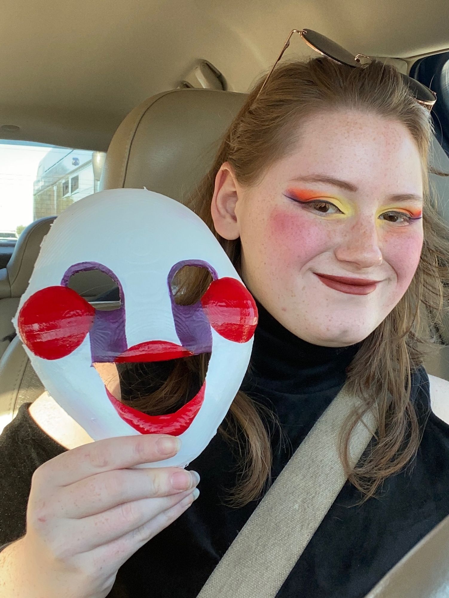 Person holding finished, painted mask