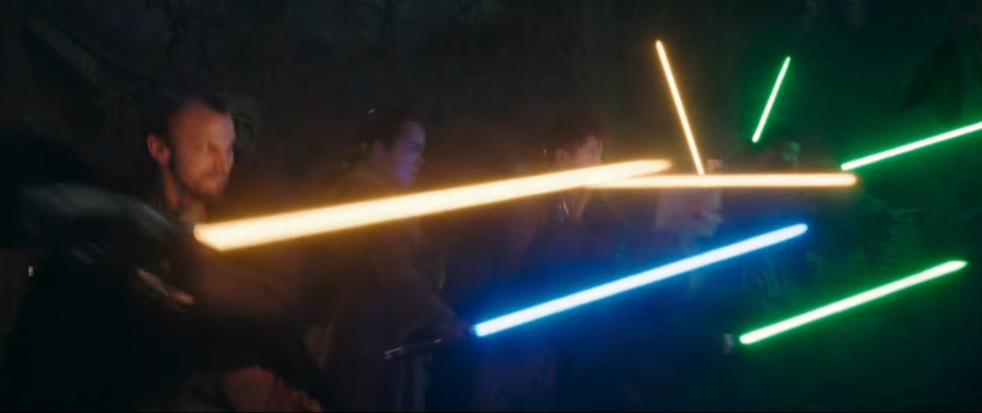 A line of Jedi ignite their lightsabres for battle: green, blue, and gold.